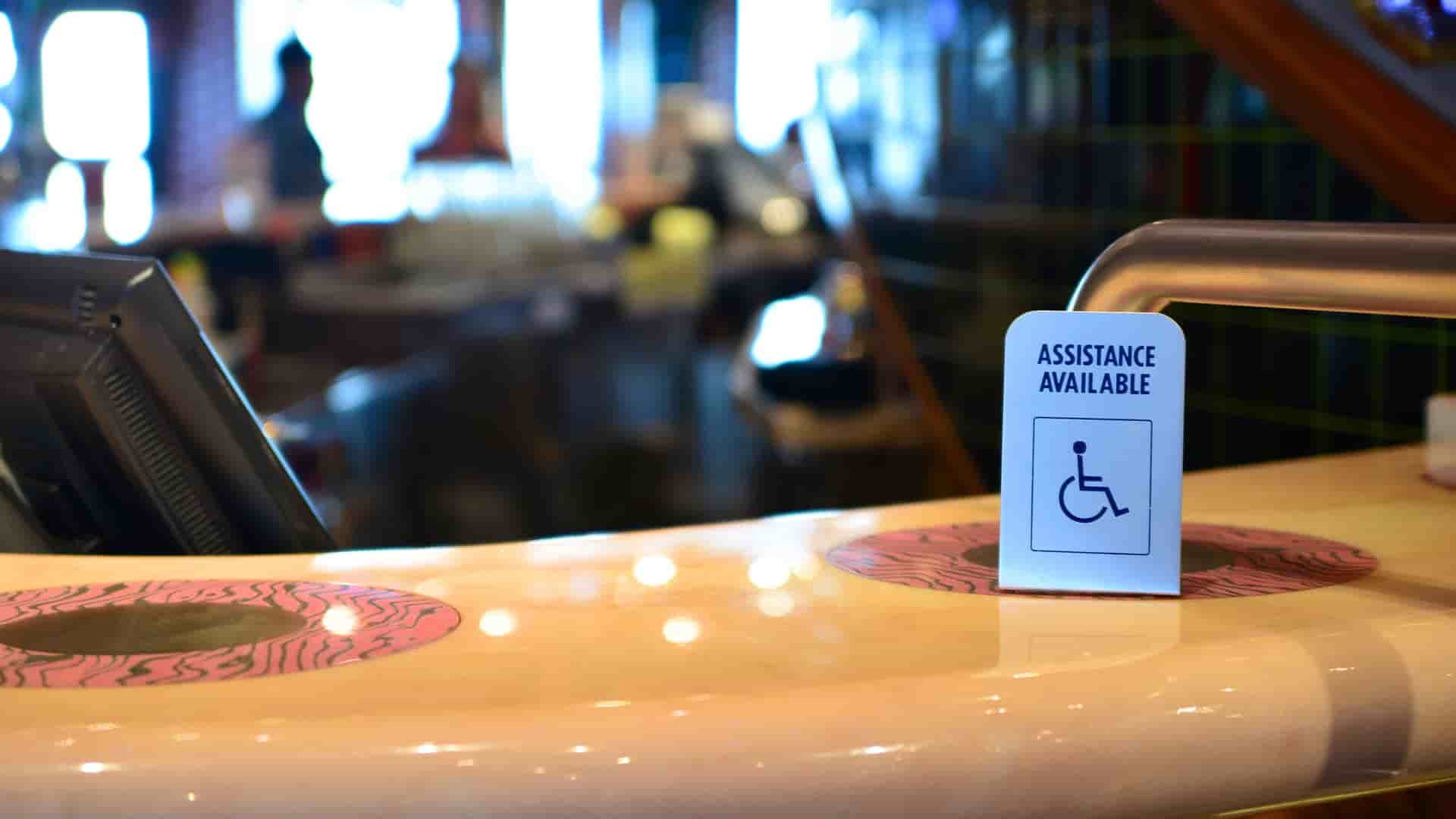 Accessibility assistance available sign on a bar counter aboard a cruise ship.