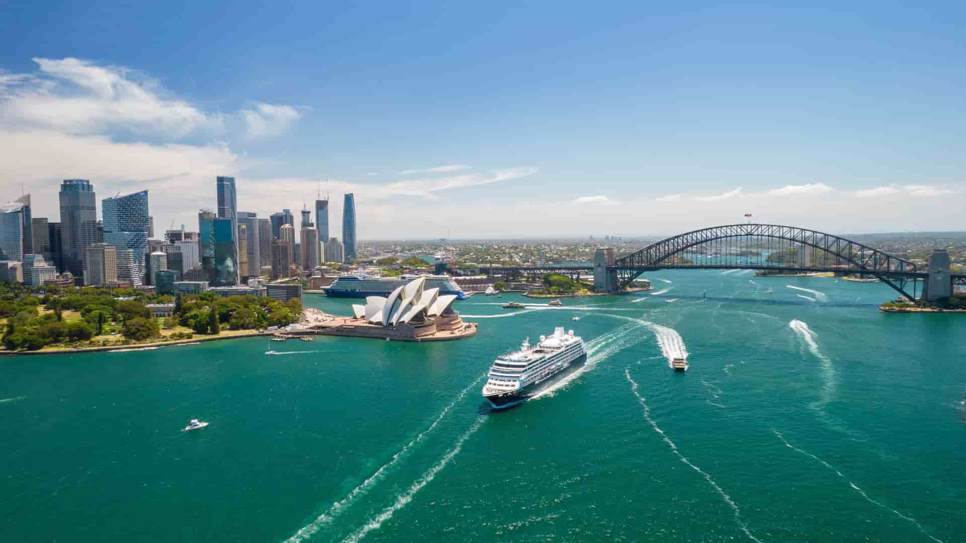 An Azamara cruise ship sailing in the Sydney Harbour in front of the Sydney Opera House.
