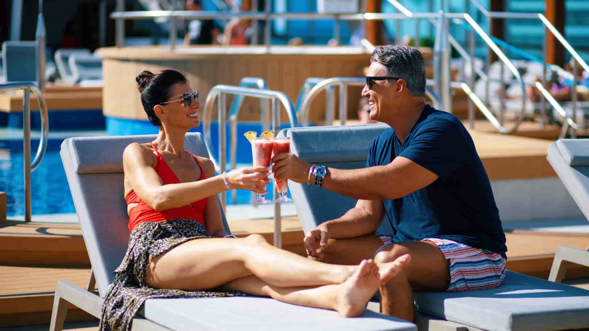 Couple relaxing on the pool deck of Azamara Onward.