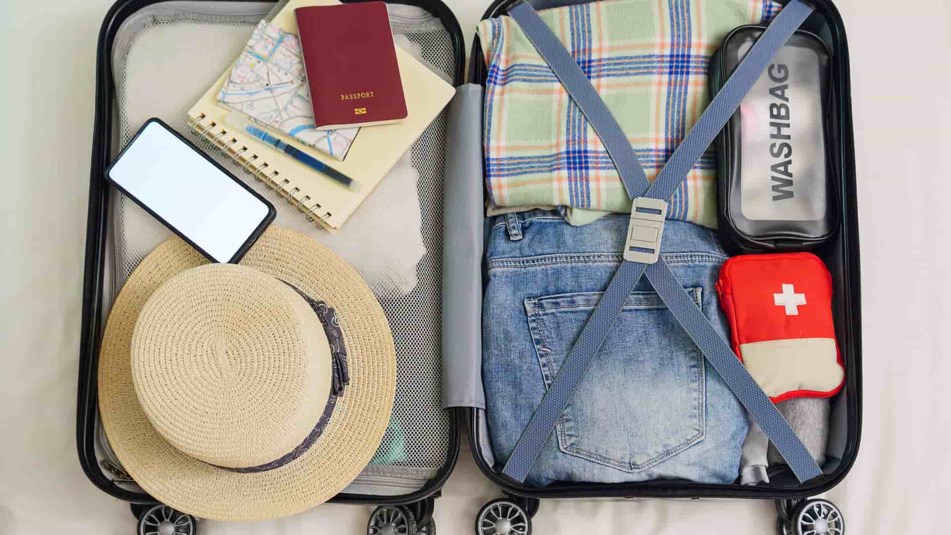 A top down shot of an open suitcase organized with travel essentials.