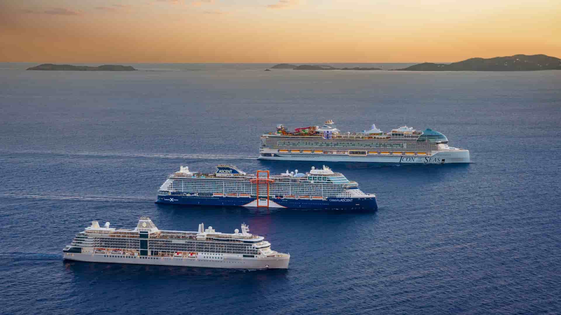 An aerial view of Celebrity Ascent cruise ship sailing with the Royal Caribbean Icon of the Seas and a Silver Spirit-class ship on the water near islands at dusk.