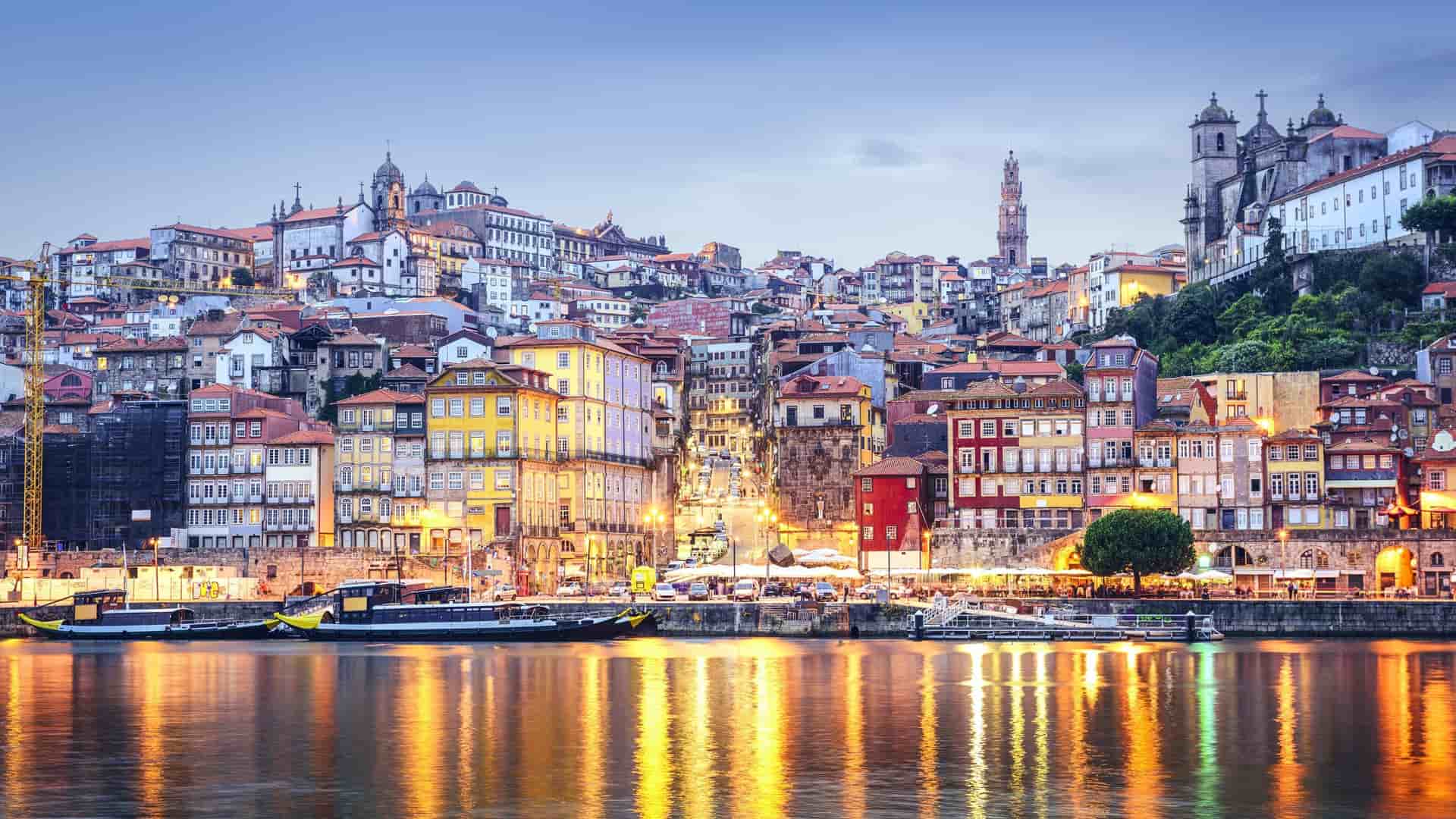Historic cityscape of Porto, Portugal, along the Douro River at dusk.