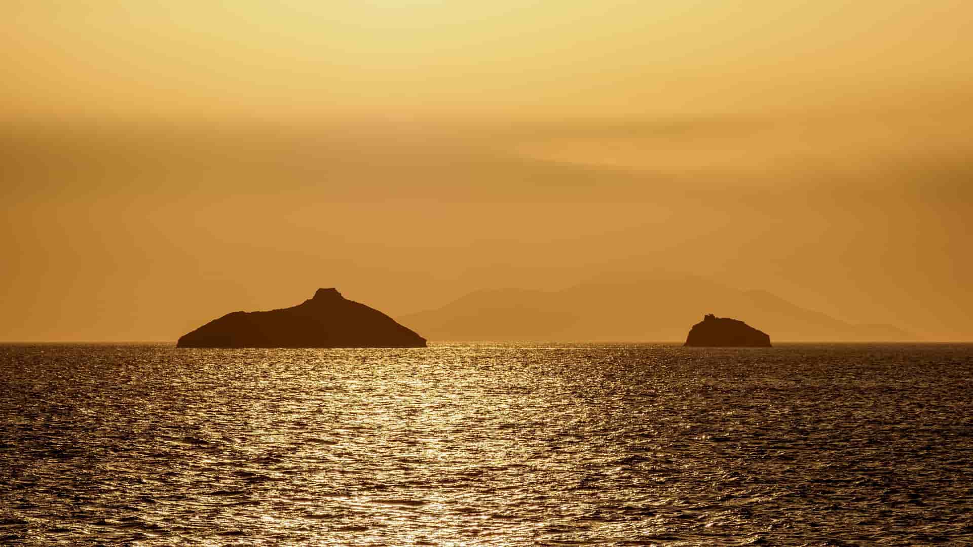 A beautiful sunset shot of the remote Isla Guy Fawkes islands, with the sun's golden light reflecting off the shimmering water.