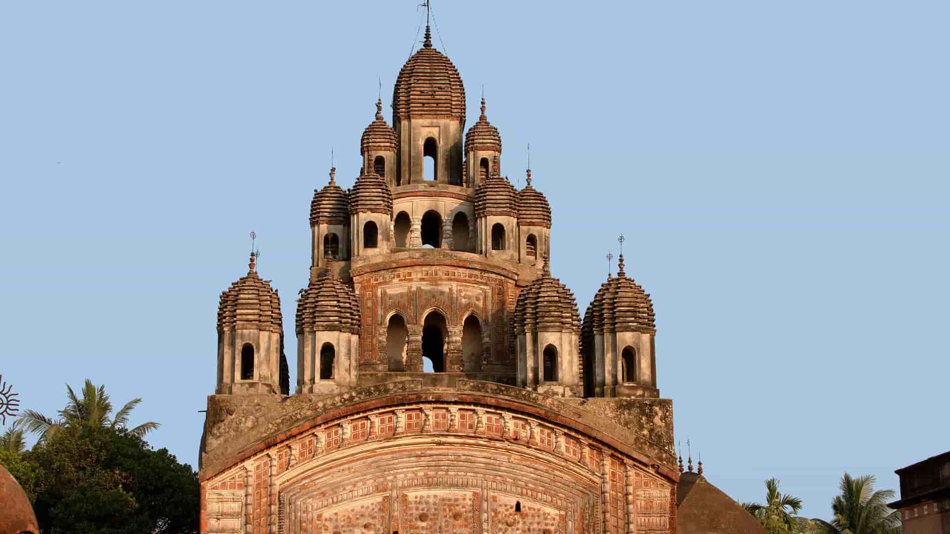 A stunning close-up of the architectural detail of the Nabakailash or 108 Shiva Temples complex in Kalna, India, showcasing the unique terracotta temple spires against a clear sky.