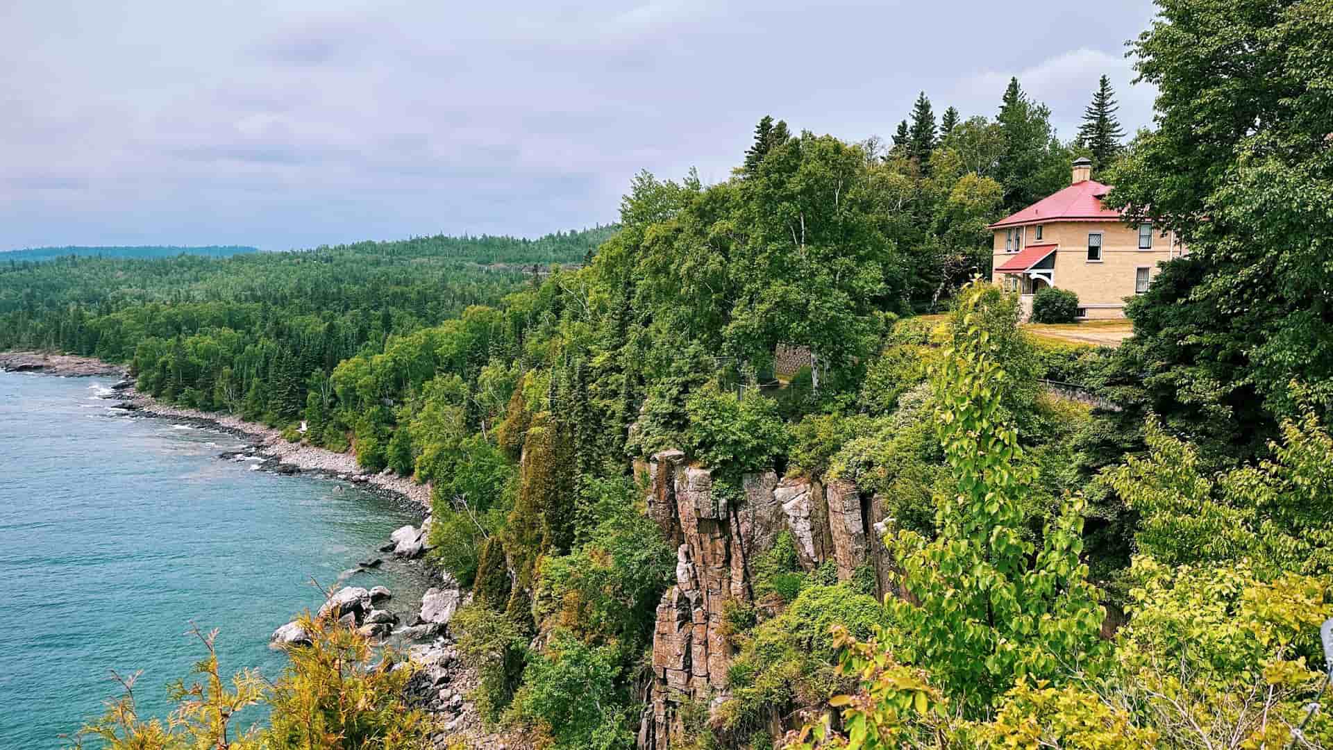 A beautiful view of the historic Split Rock Lighthouse keeper's house perched on a cliff overlooking the deep blue waters of Lake Superior.