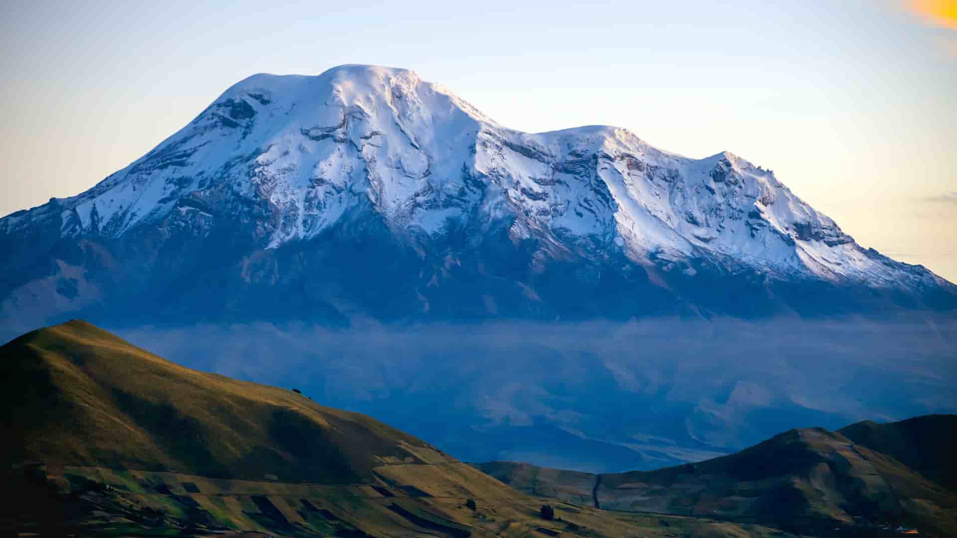 "A breathtaking view of the snow-capped Chimborazo volcano, the highest peak in Ecuador, with a dramatic, volcanic landscape, near the city of Riobamba.  "