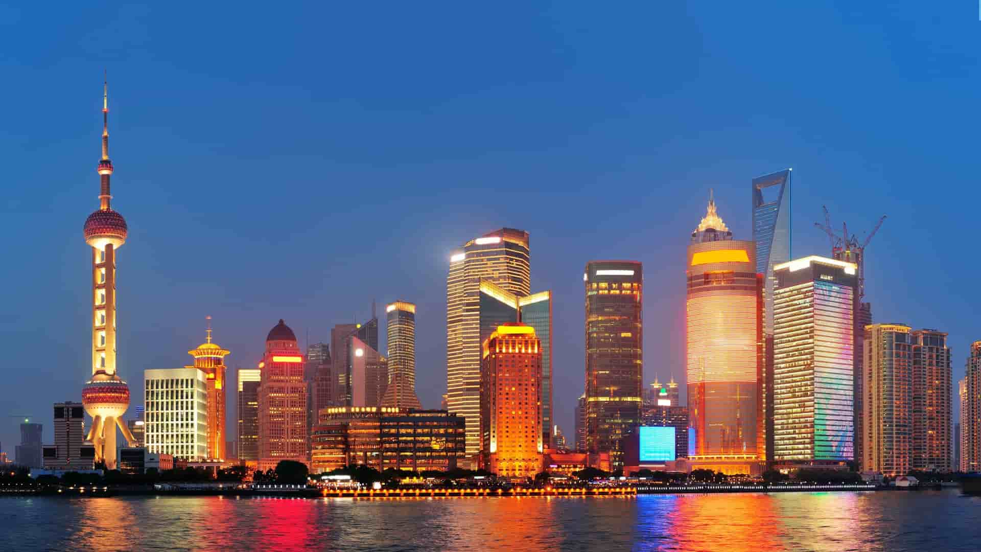 Shanghai skyline at night with skyscrapers and the Oriental Pearl TV Tower.