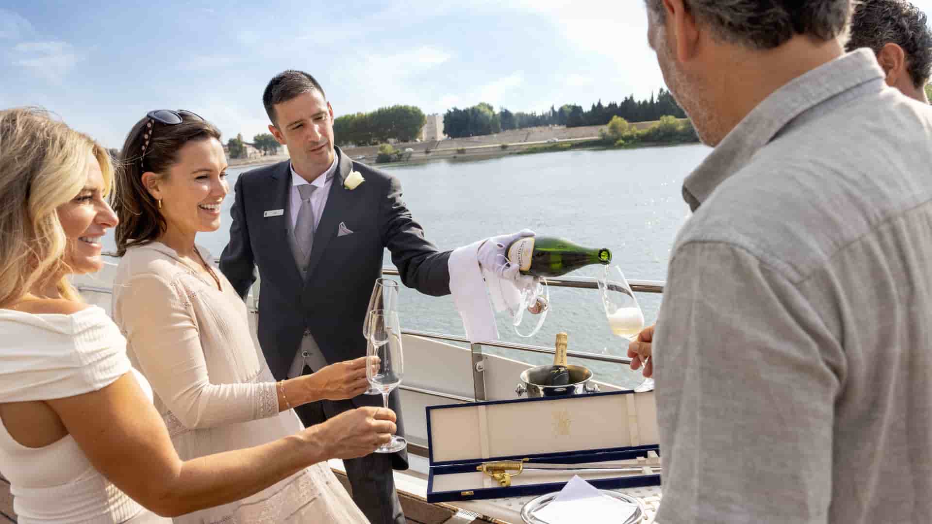Butler serving guests champagne during an exclusive welcome party on the SS Catherine.