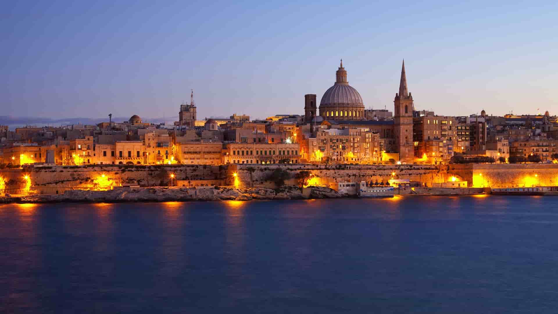 Valletta, Malta skyline with illuminated buildings at dusk.