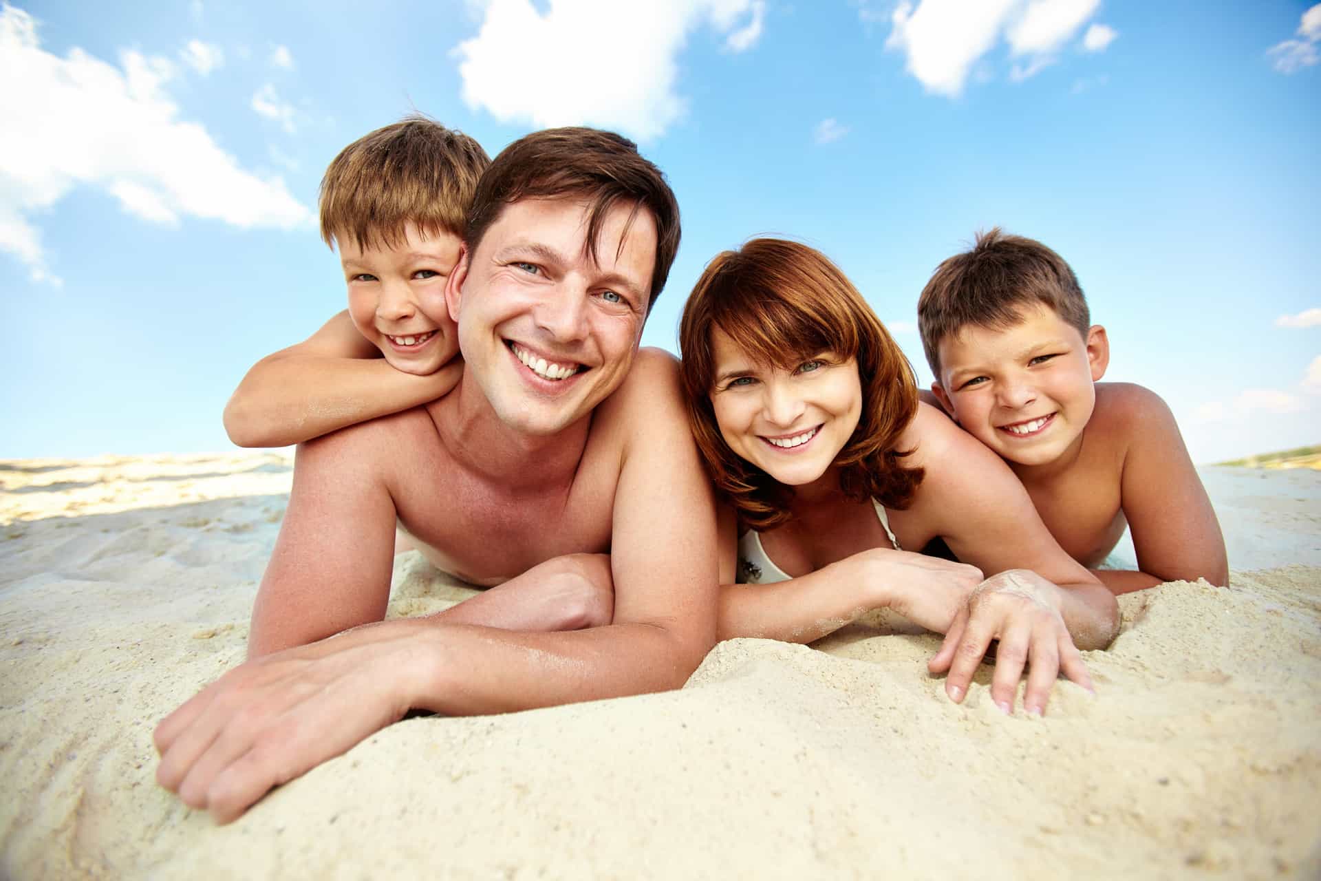 Family with kids enjoying lying on the sandy beach.
