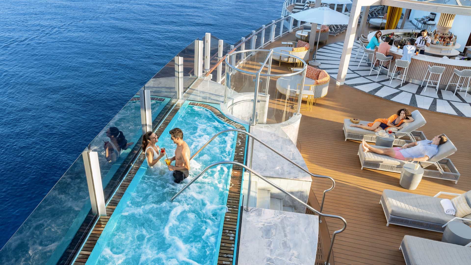 Couple sitting in the pool at the adults only Vibe Beach Club on Norwegian Prima.