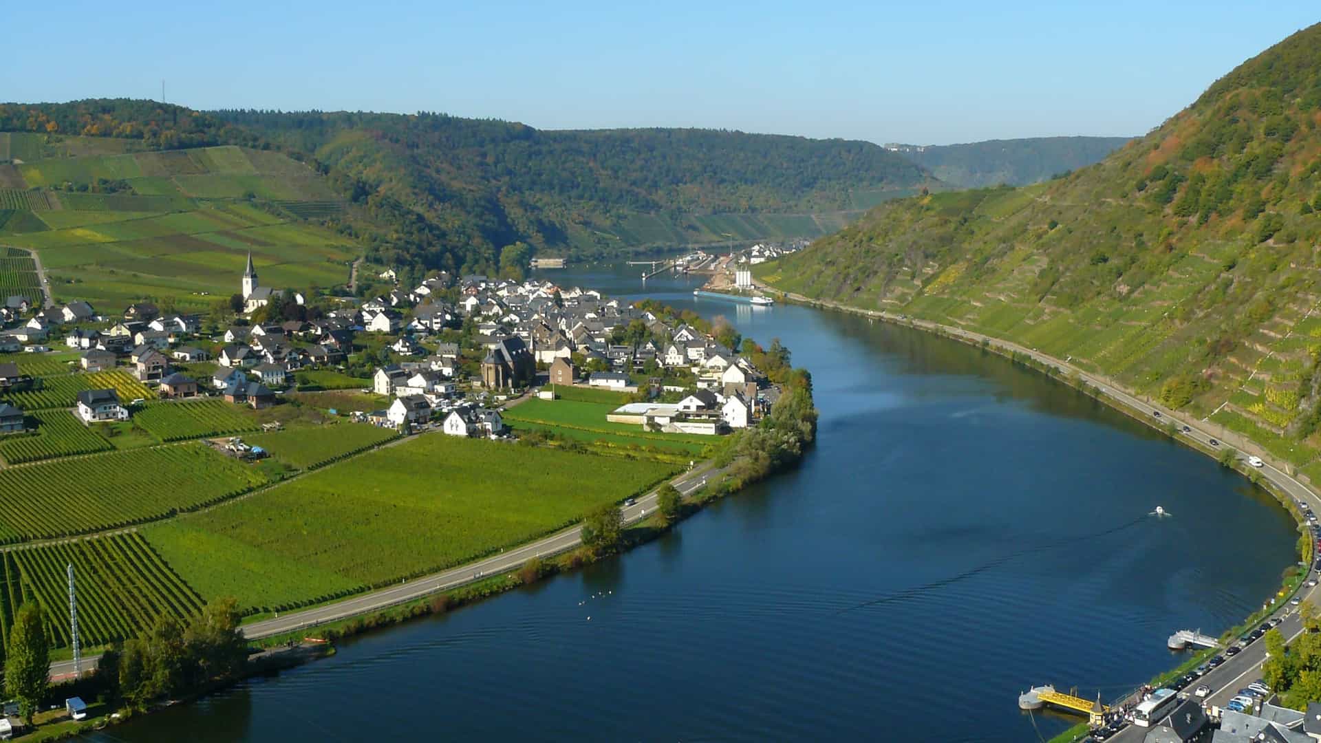 Scenic view of the Moselle River Valley in Germany, showcasing winding waterways, lush vineyards, and a charming village, a classic landscape experienced on an Avalon Waterways river cruise.