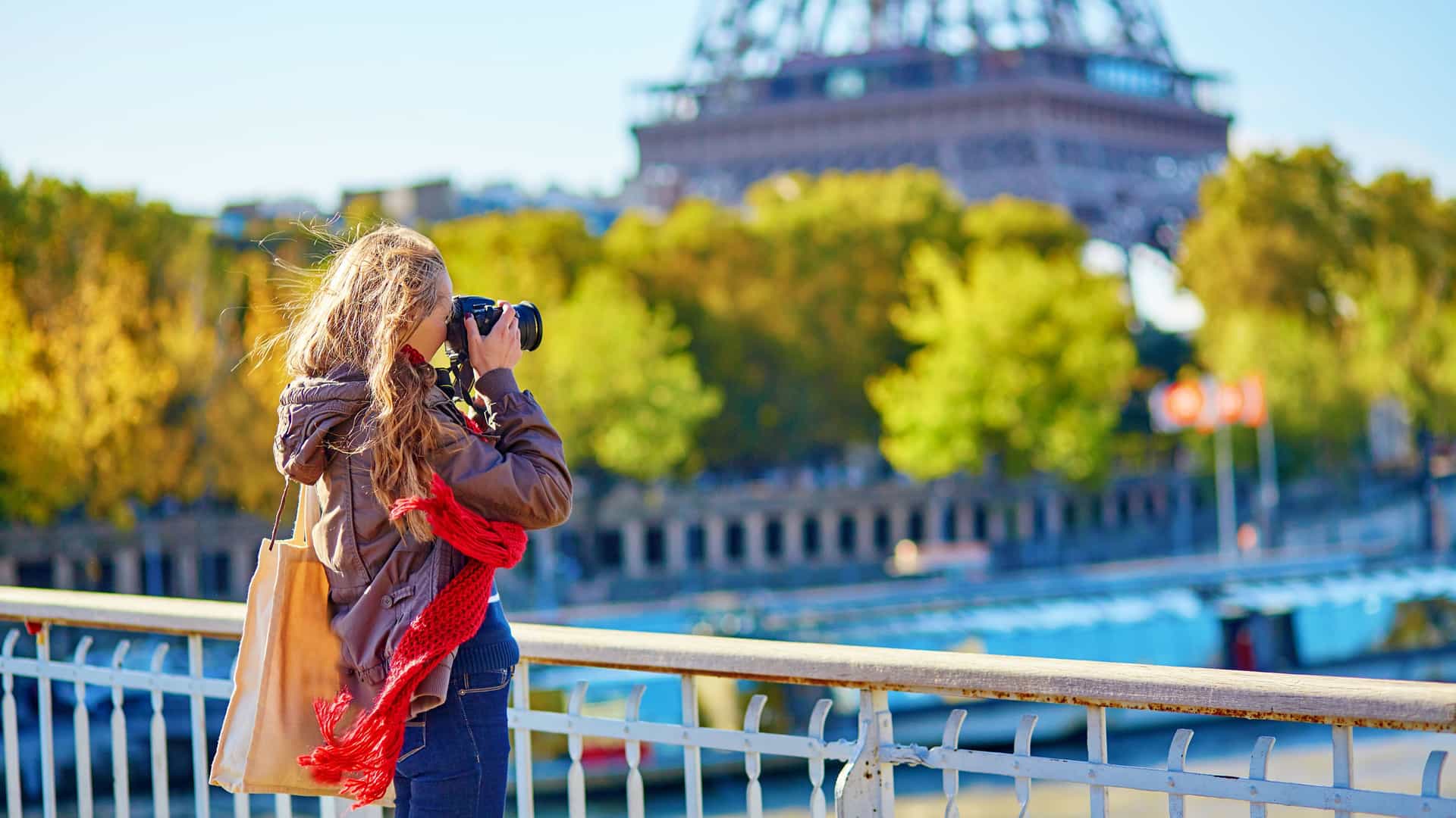 Tourist taking photos of the Eifel Tower in Paris, France in autumn.