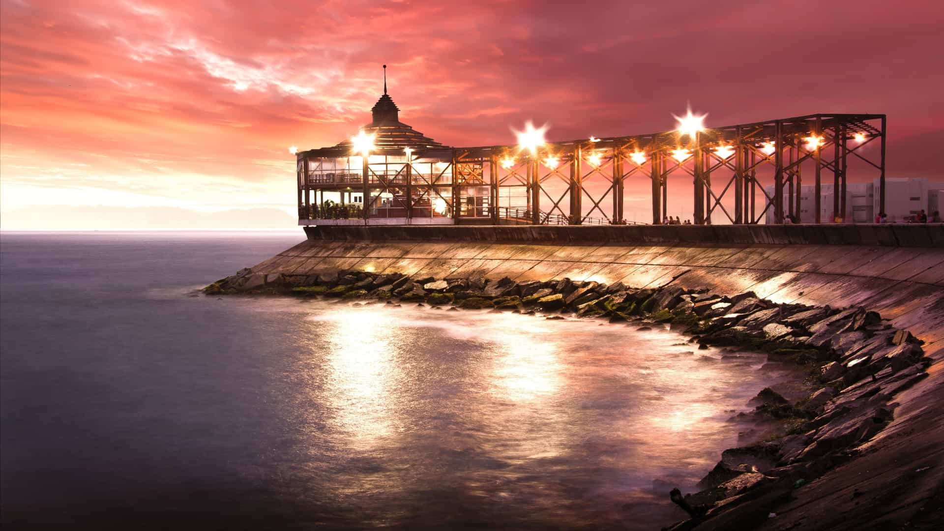 Modern building illuminated at sunset along the coast in Callao, Peru.