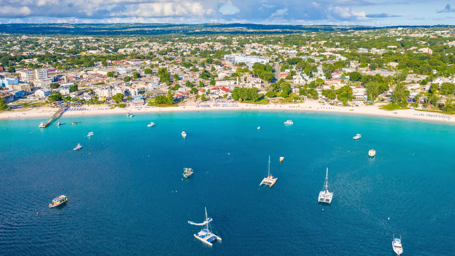 Aerial view of Barbados coastline with sandy beach, turquoise waters, and cityscape on a Celebrity Cruises Eastern Caribbean itinerary.