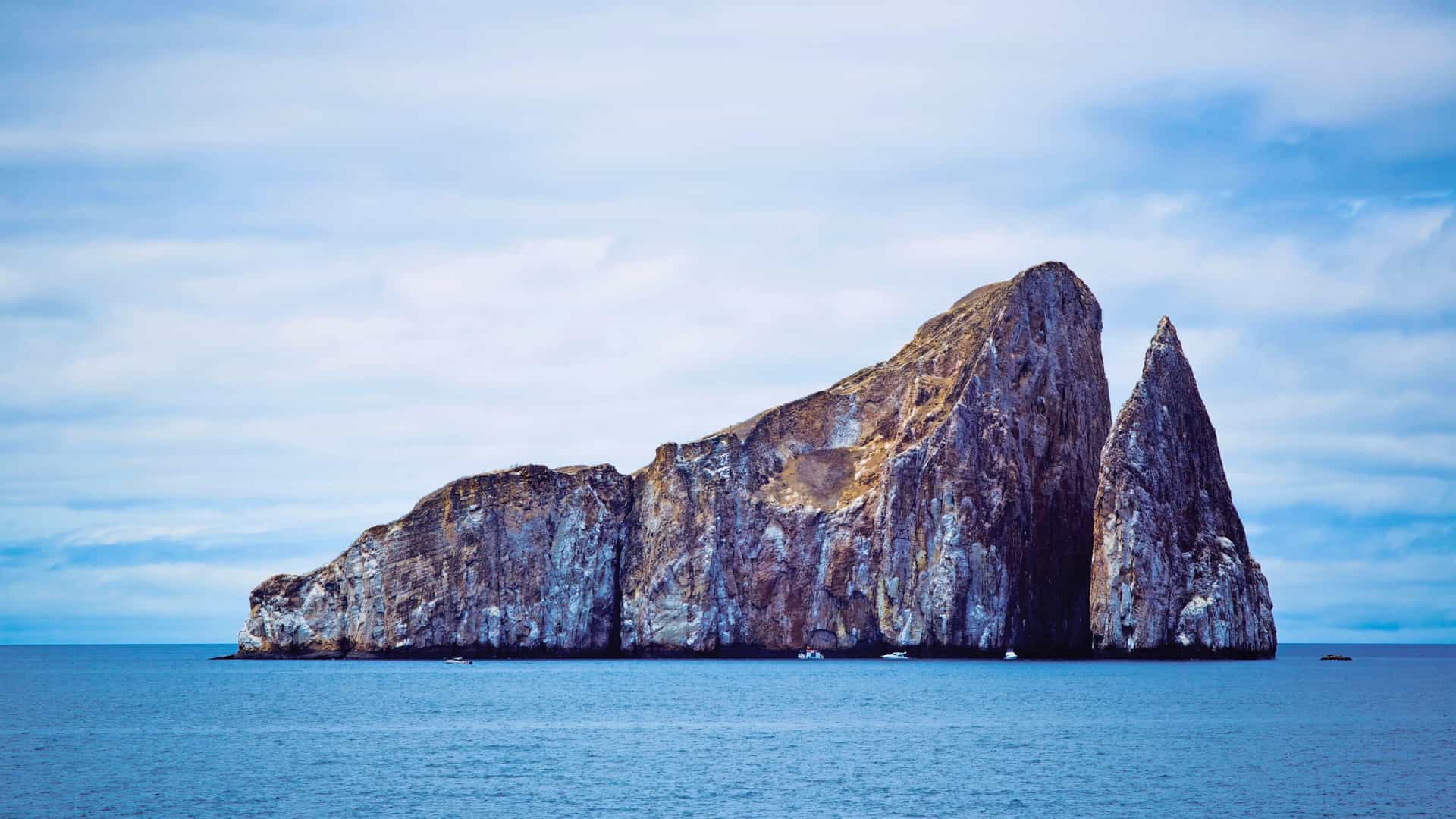Kicker Rock rising from turquoise waters in the Galapagos on a Celebrity Cruises expedition voyage.