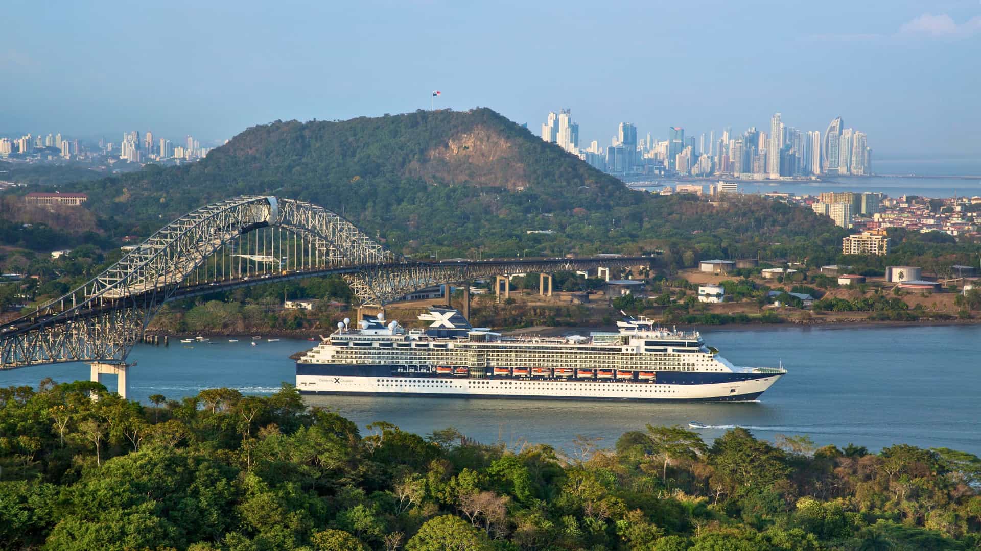 Aerial view of Celebrity ship in the Panama Canal with Bridge of the Americas and Panama City skyline in the background.
