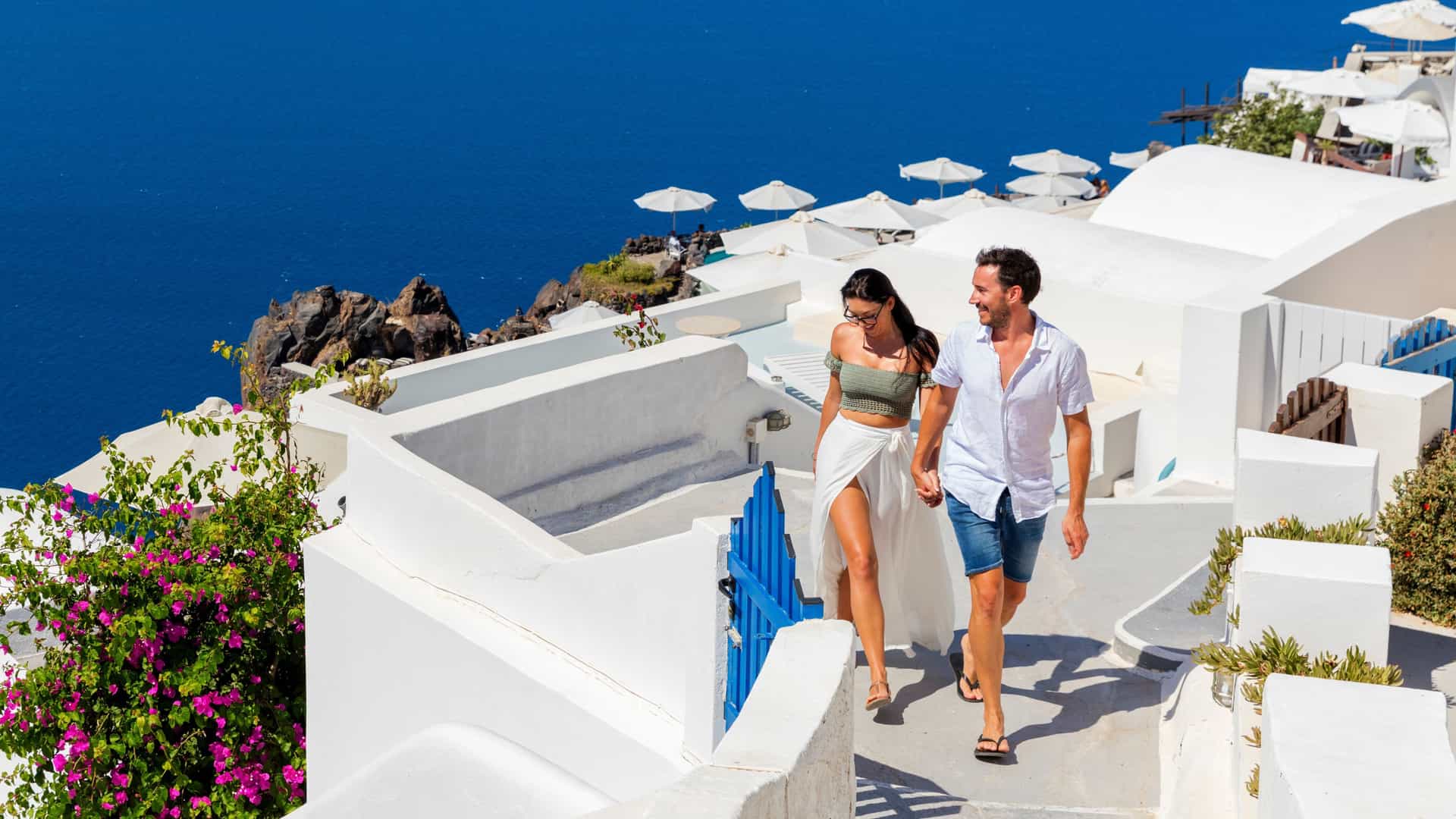 Couple walking on coast in Santorini, Greece.
