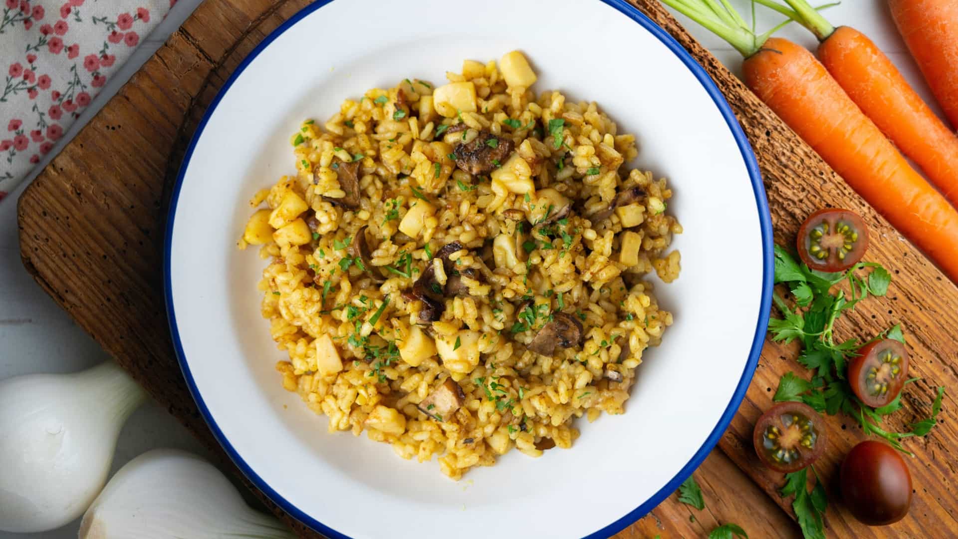A top-down view of a classic Spanish dish, Arroz a Banda, a type of rice paella cooked with cuttlefish and seafood stock, served with a lemon wedge.