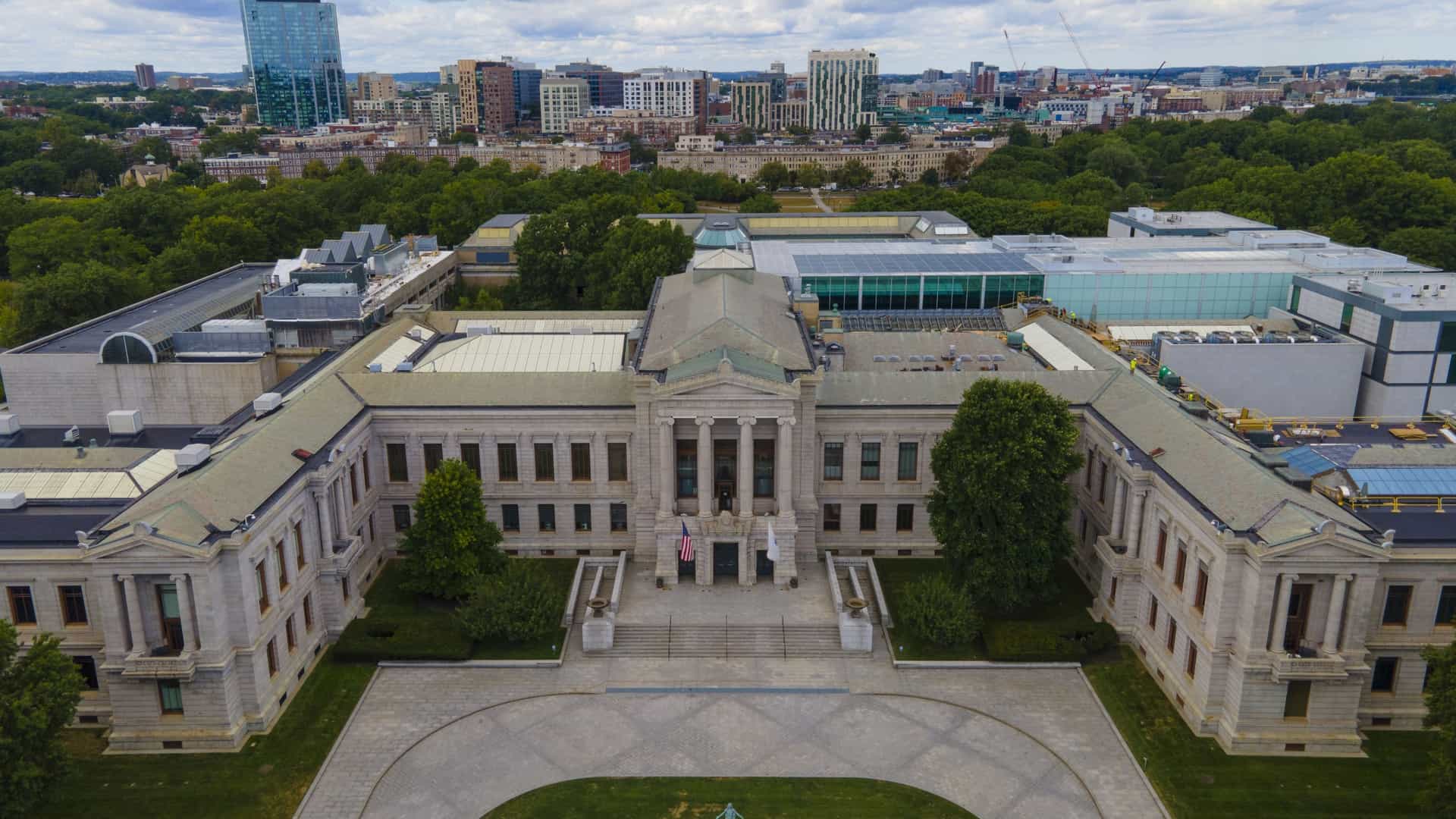  A daytime photograph of the Museum of Fine Arts in Boston, Massachusetts, located at 465 Huntington Avenue. The image shows the neoclassical facade of the building with its grand columns, and the wide steps leading to the main entrance.