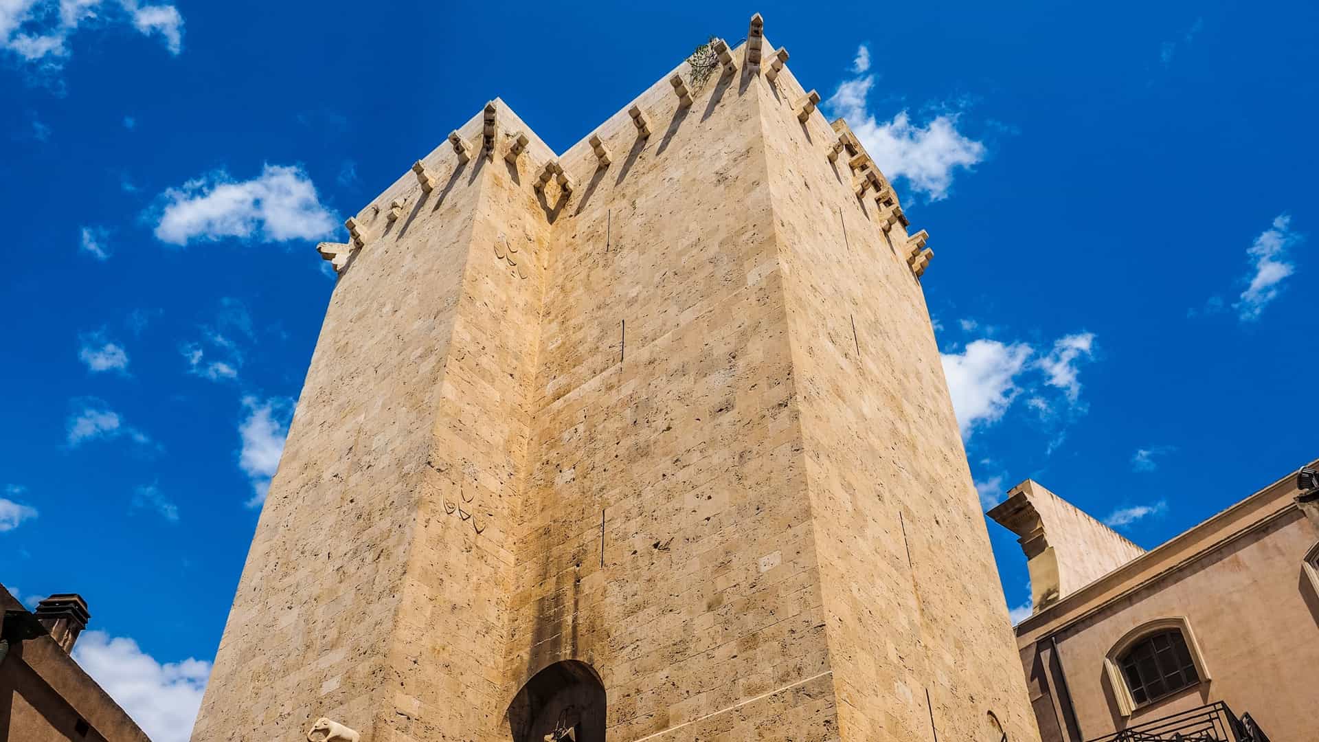 The Torre dell'Elefante (Tower of the Elephant) in Cagliari, Sardinia, Italy, a high medieval defensive tower built of white limestone, with the statue of an elephant carved on one side.