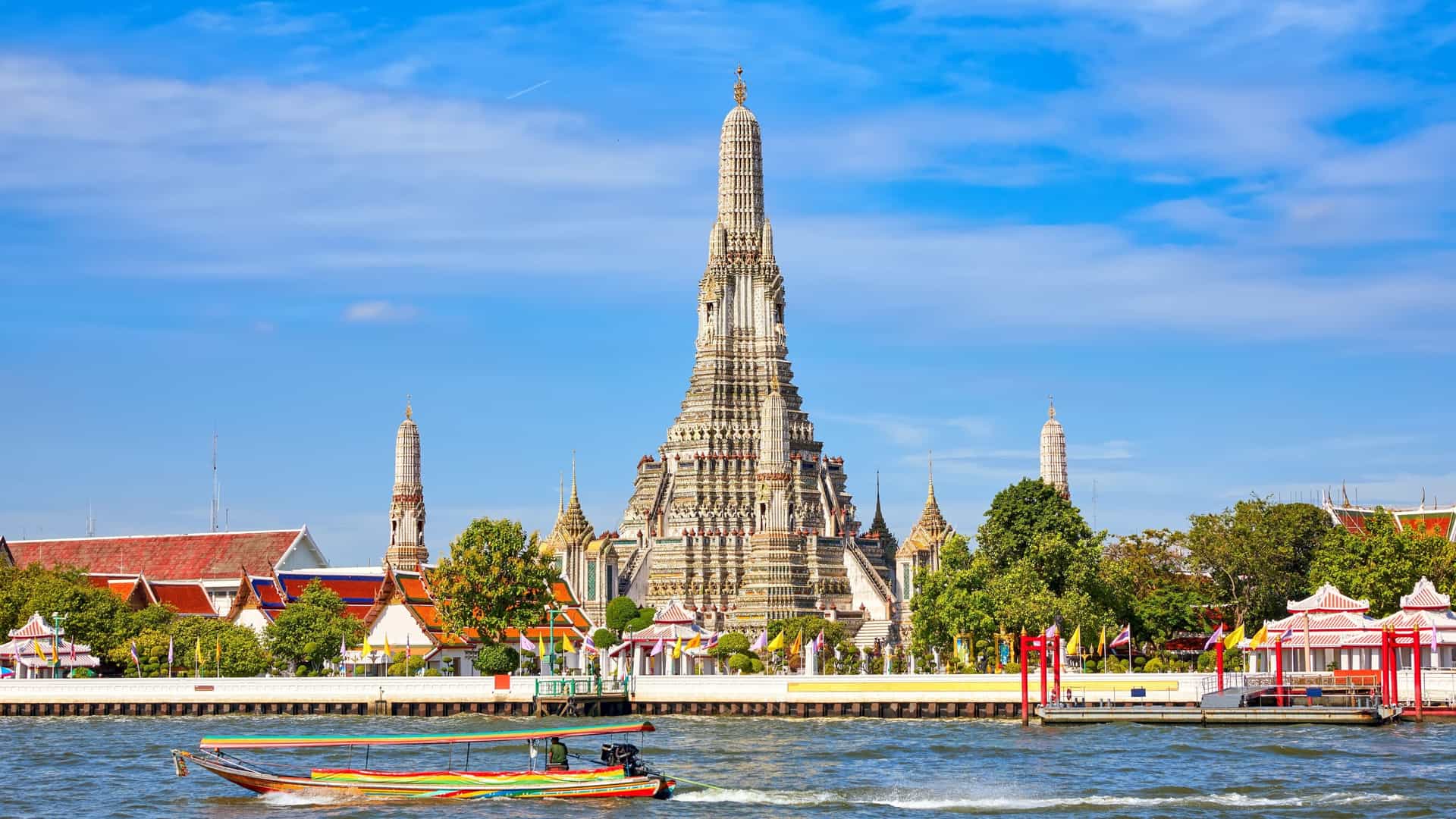  Wat Arun, or the Temple of Dawn, is a prominent Buddhist temple on the Chao Phraya River in Bangkok, Thailand. The central spire, or prang, is adorned with intricate patterns of colorful porcelain and shells and is surrounded by four smaller spires.