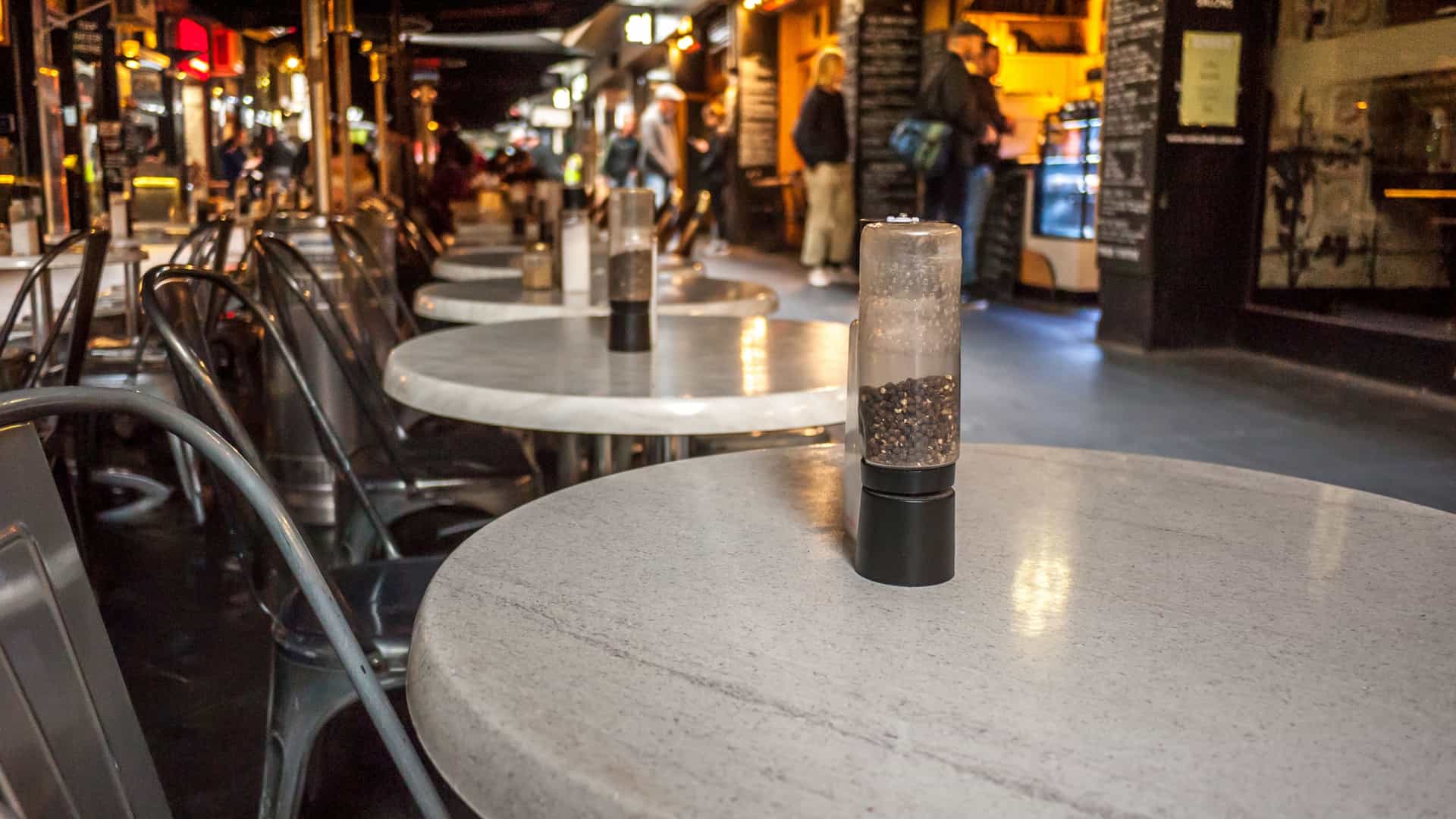 A view of the bustling laneway cafe scene on Degraves Street in Melbourne, famous for its dense outdoor seating and Parisian-style dining. This urban atmosphere contrasts with the relaxed, alfresco dining experience offered at the GOMA Bistro or QAG Cafe, which are part of the Queensland Art Gallery and Gallery of Modern Art (QAGOMA) complex in Brisbane.