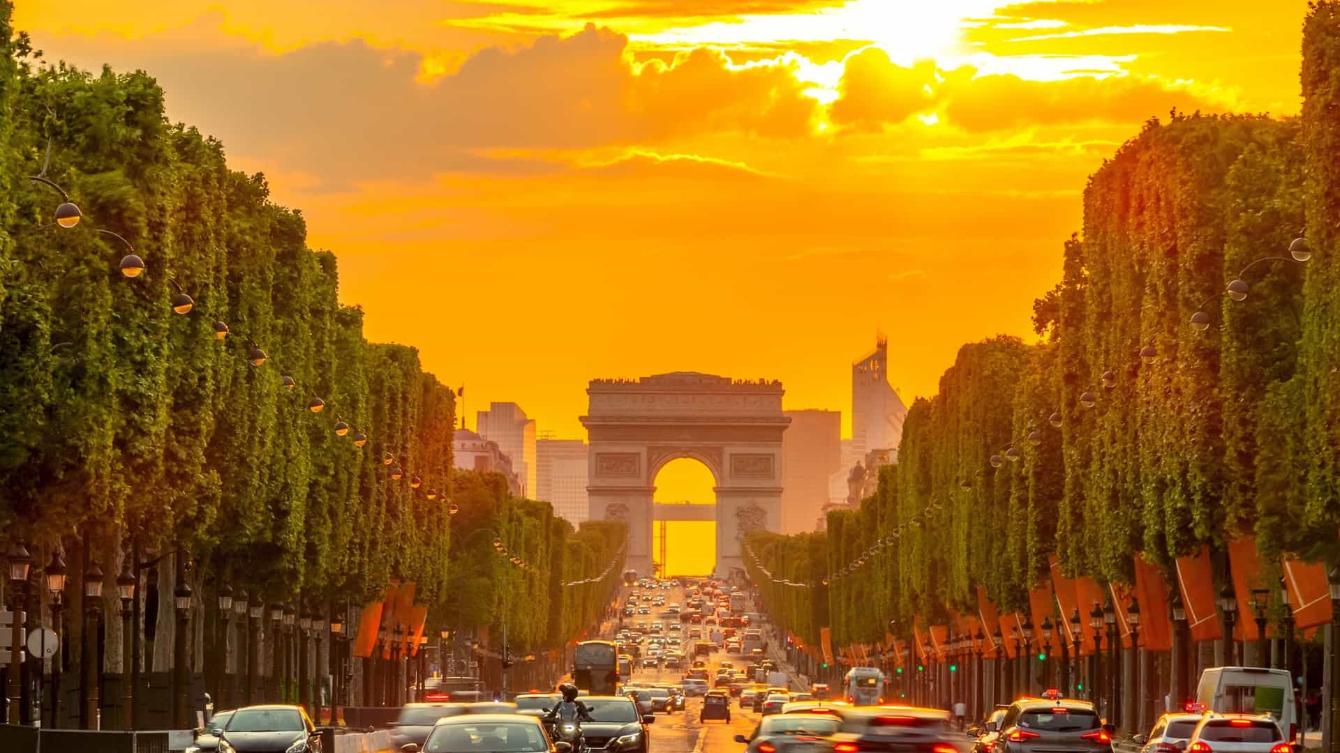  A view down the Avenue des Champs Élysées in Paris, with the Arc de Triomphe visible at the end. The image captures the iconic Parisian street with its wide boulevard and the famous monument at the center of the Place Charles de Gaulle.