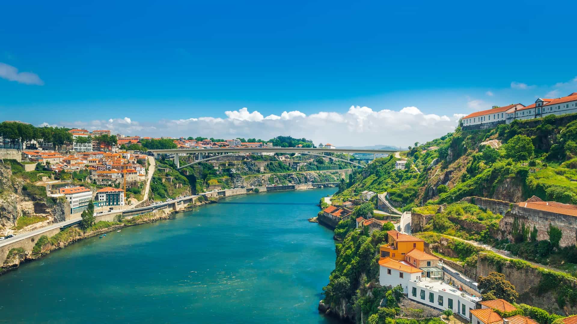 Panoramic view of the hills of Vila Nova de Gaia in Porto, Portugal, featuring the circular Monastery of Serra do Pilar and traditional Port wine cellars, with the Ponte Infante D. Henrique bridge spanning the Douro River.