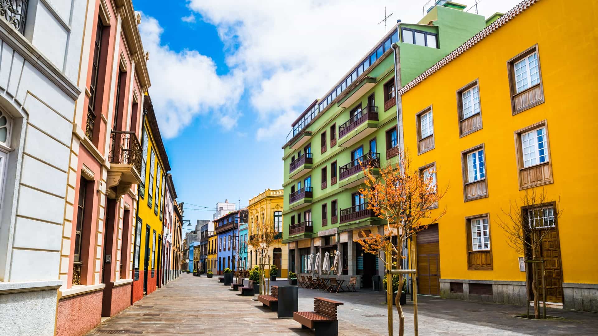  A view of a pedestrian city street in the historic center of San Cristóbal de La Laguna, Tenerife, Canary Islands, Spain, featuring colorful colonial style buildings with traditional wooden balconies and cobblestones.