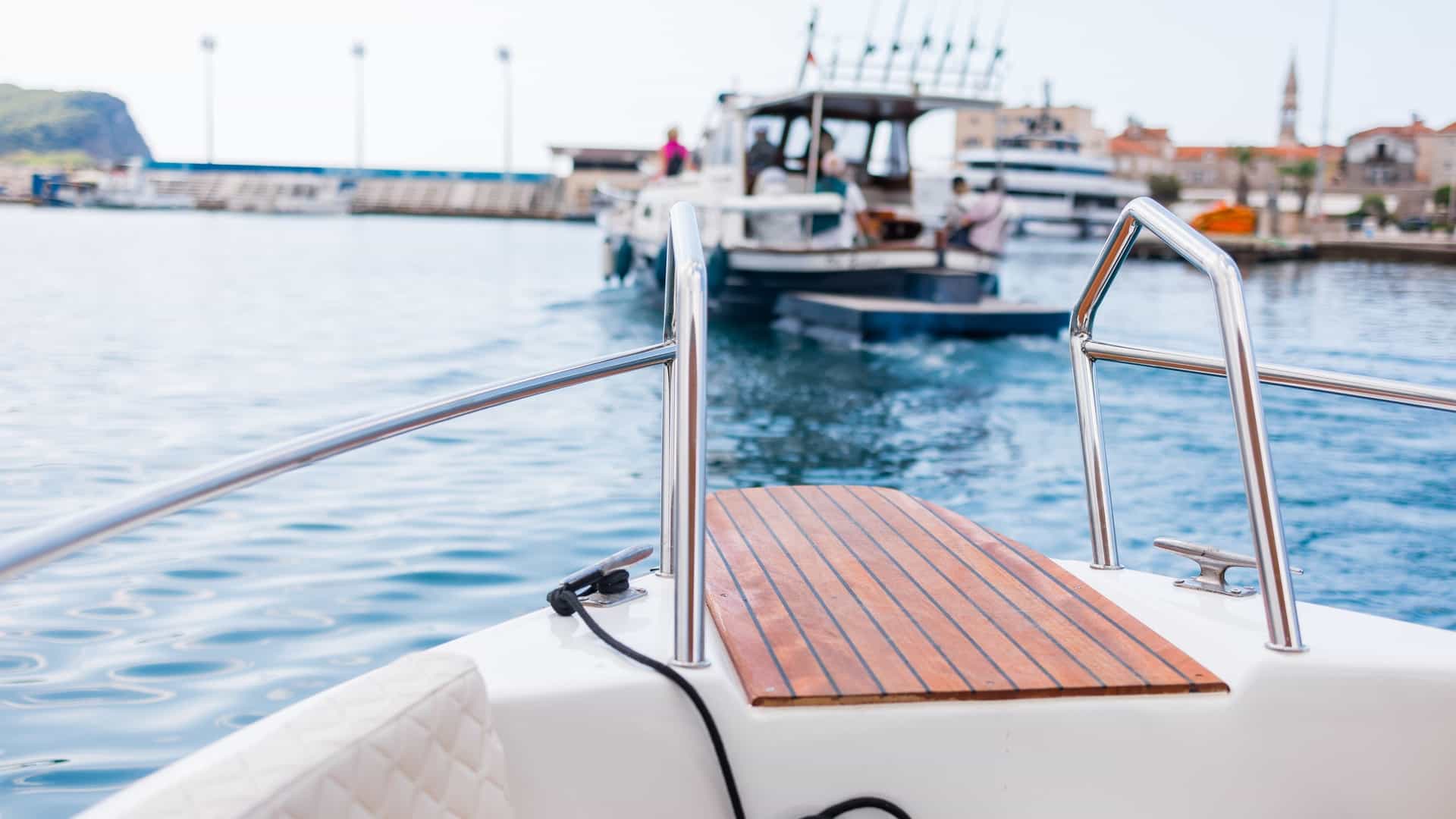  A dynamic view of the Valparaíso harbor in Chile, featuring several small motorboats navigating the water in the foreground. The scene is dominated by the city's iconic elements: the large industrial cargo ships, dock cranes, and the backdrop of the steep, densely packed hills covered in a mosaic of brightly colored houses.