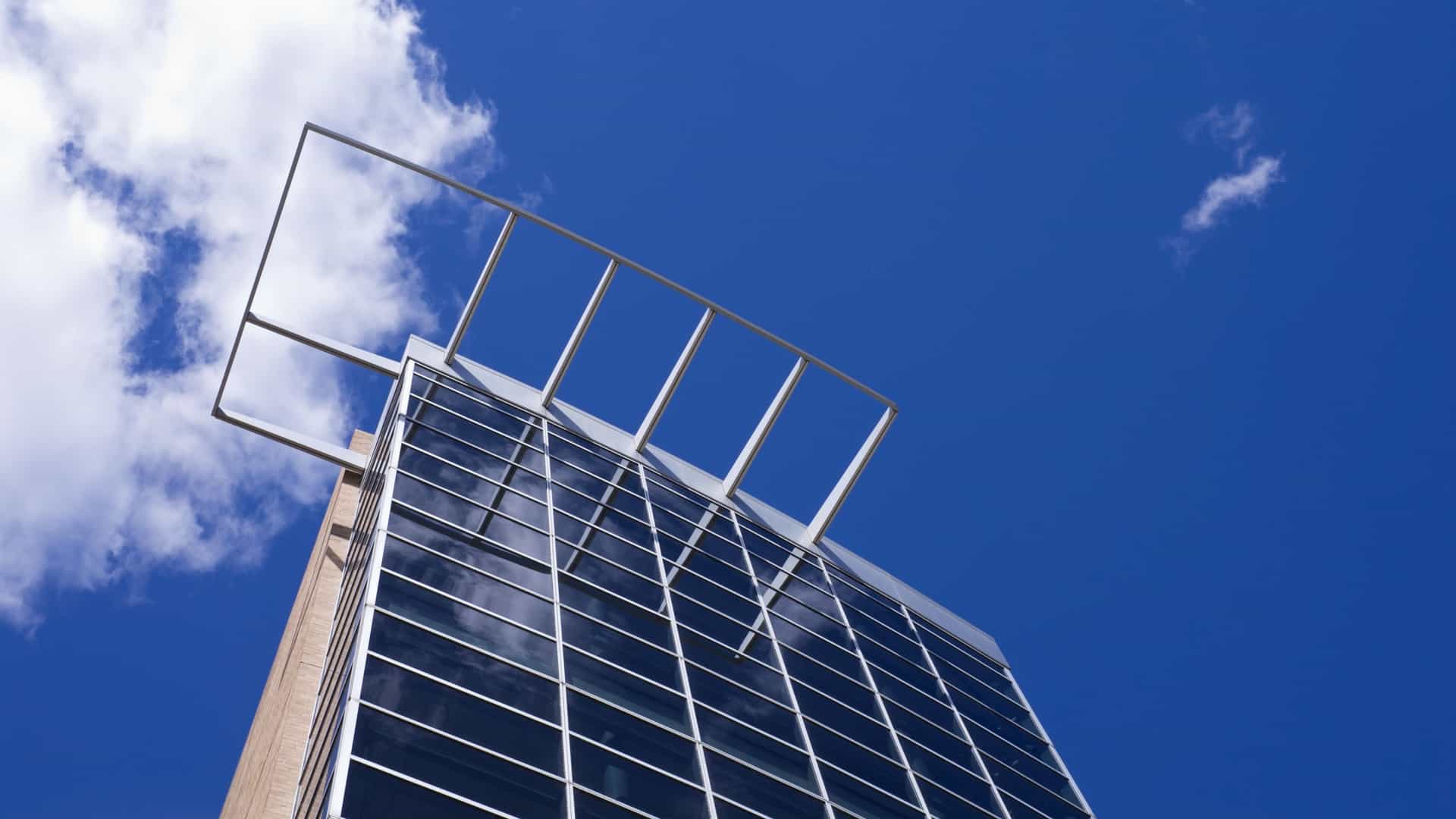  The modern, multi story building of the Science Museum of Minnesota in Saint Paul, showcasing its angular and geometric facade against a clear blue sky with white clouds.