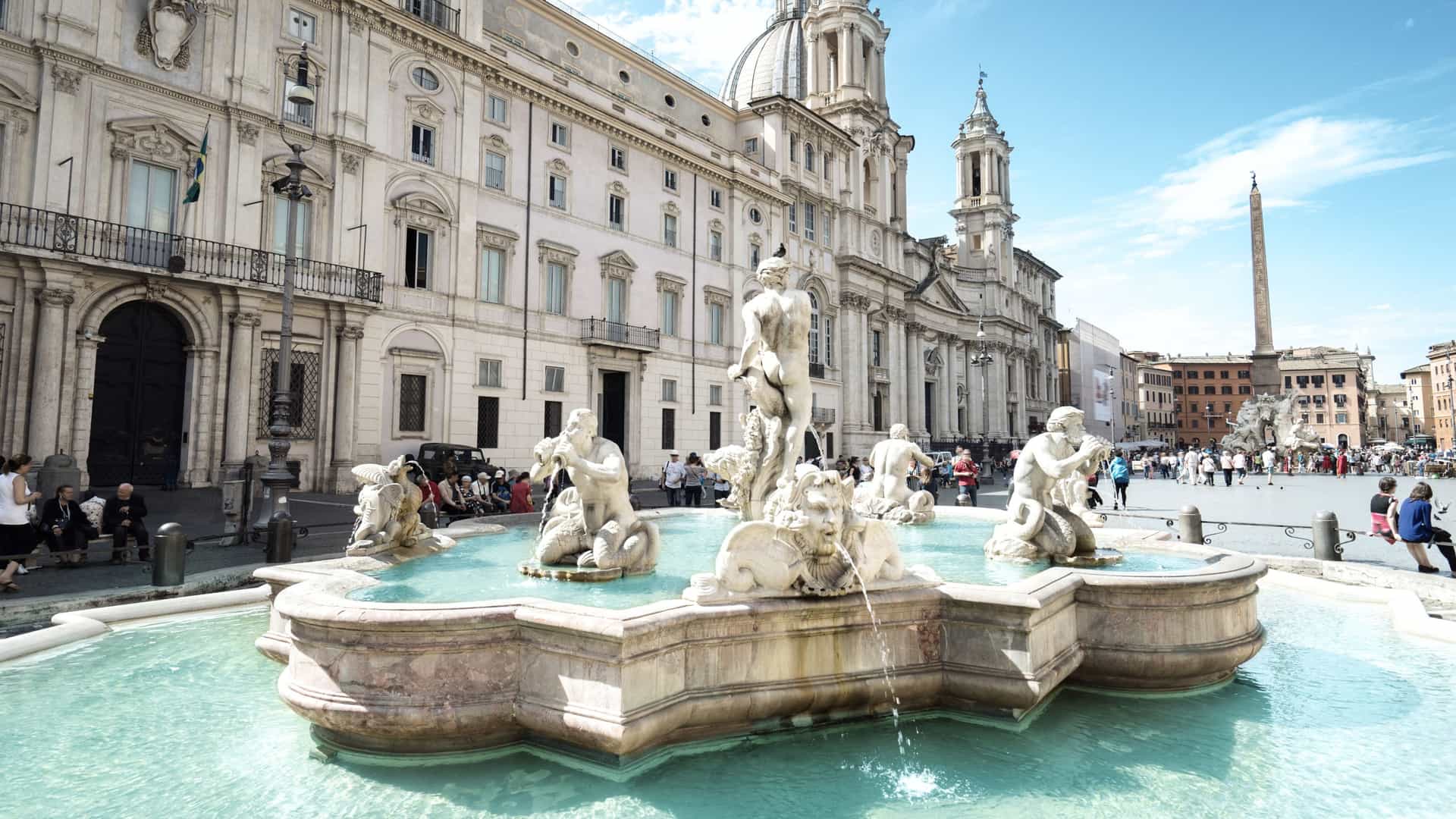 A gorgeous fountain filled with bright turquoise waters in the Piazza Navona located in Rome, Italy