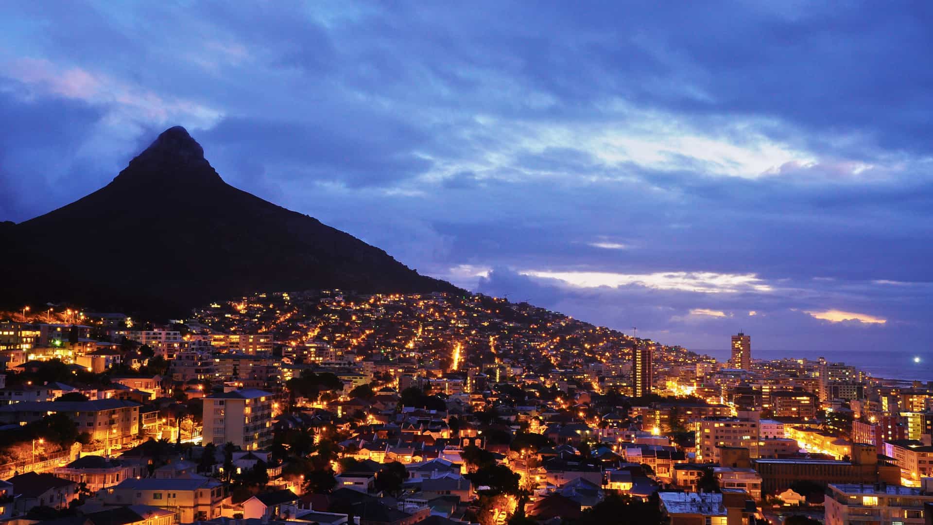 Cape Town, Africa, dazzles at night beneath Lion's Head, offering a stunning vista from a Holland America cruise.