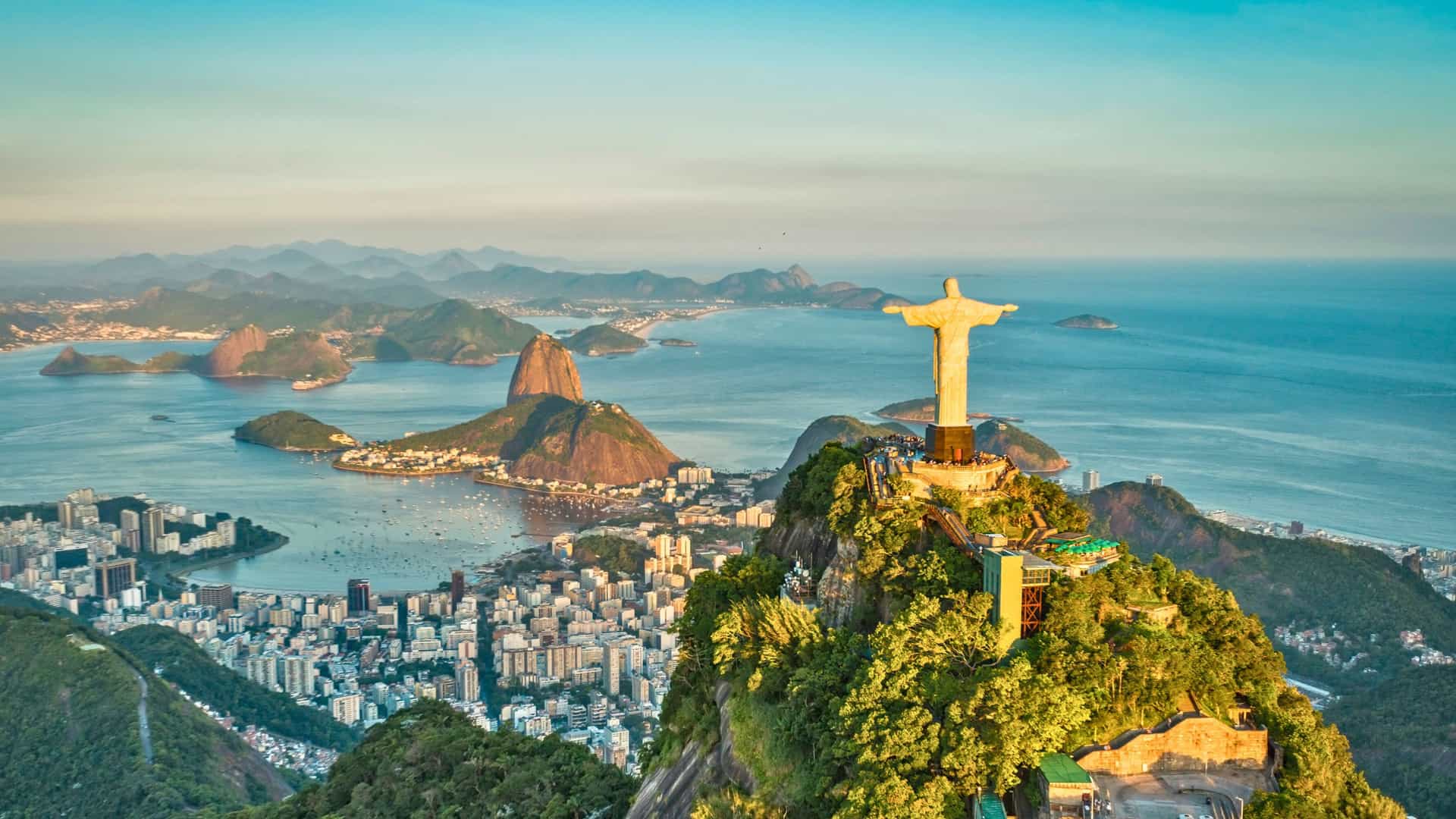 Aerial view of Rio de Janeiro with Christ the Redeemer overlooking the city, Sugarloaf Mountain, and island-speckled bay—captured during a Holland America South America cruise.