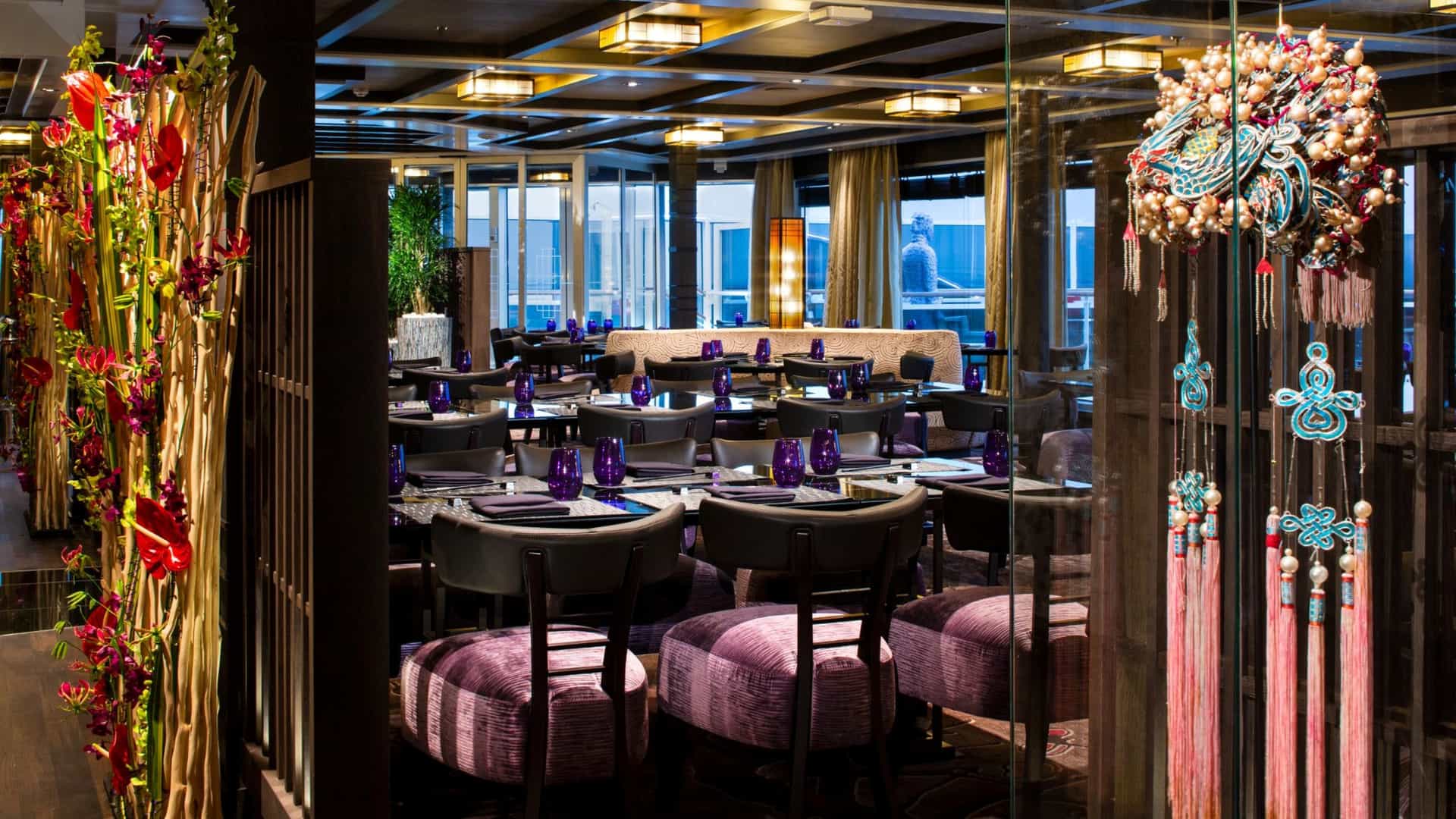Guests dine in the elegantly decorated Tamarind specialty restaurant aboard a Holland America Line cruise ship.