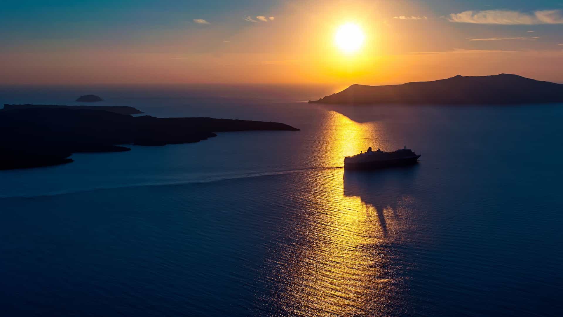 Mediterranean Sea cruise ship at sea during a beautiful Santorini sunset.