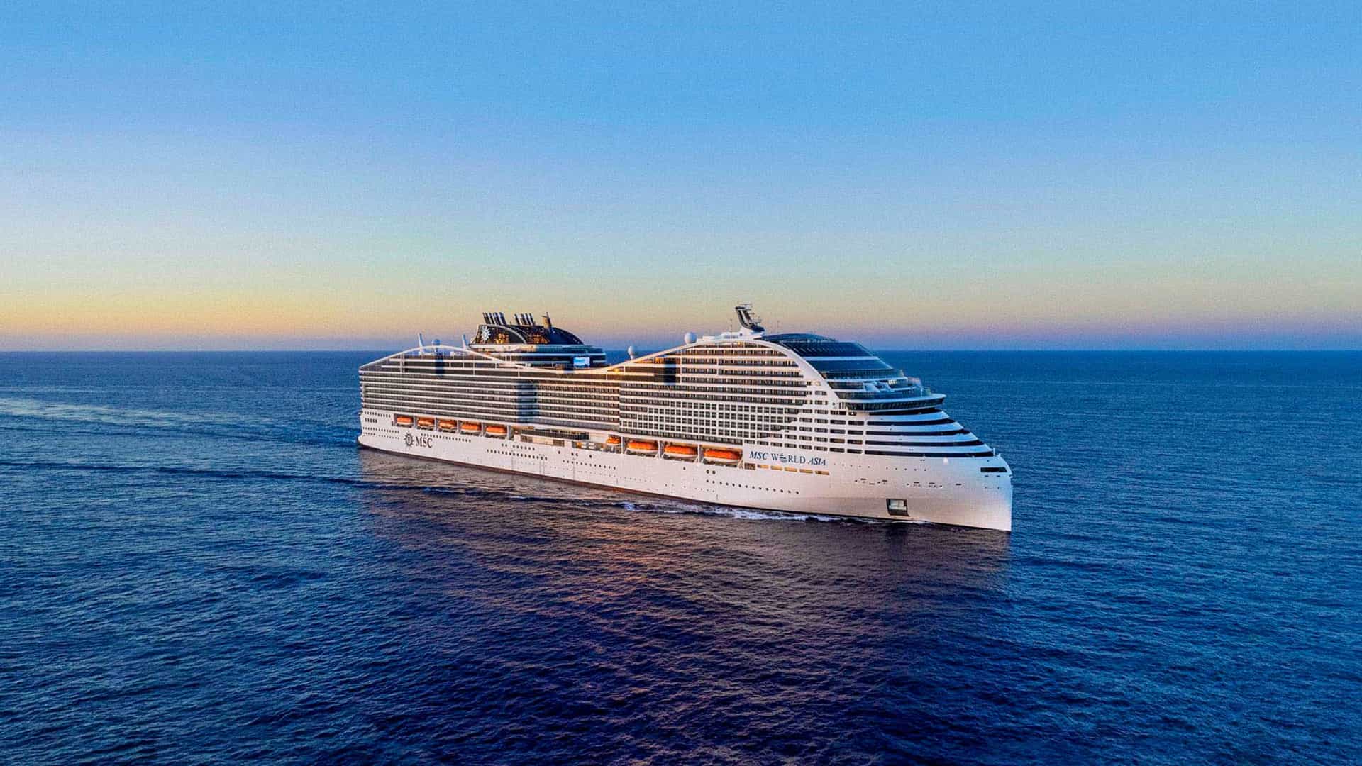 MSC world cruise ship sailing across the calm ocean at sunset with clear skies and golden reflections on the water.