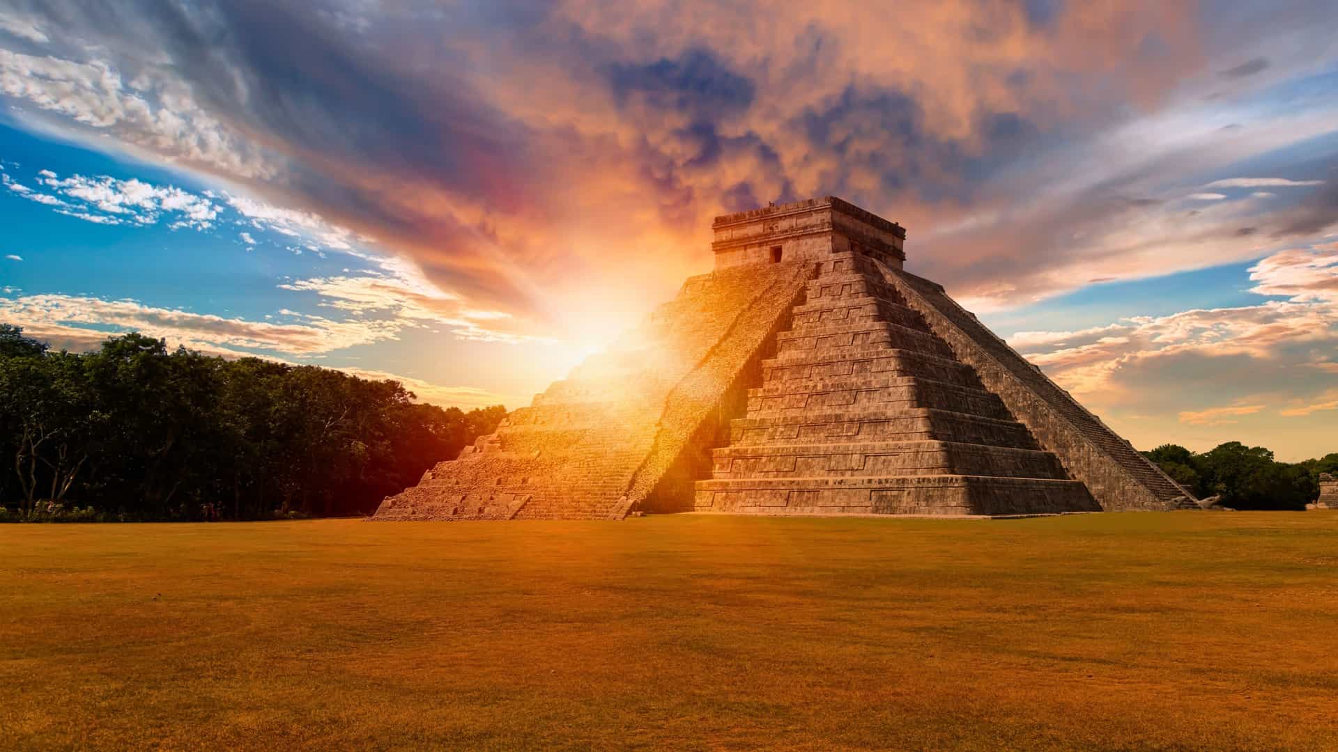 Norwegian Cruise Line shore excursion to the iconic Chichen Itza pyramid (El Castillo) in Mexico, a dramatic highlight of Western Caribbean cruises, beautifully lit by a sunset.