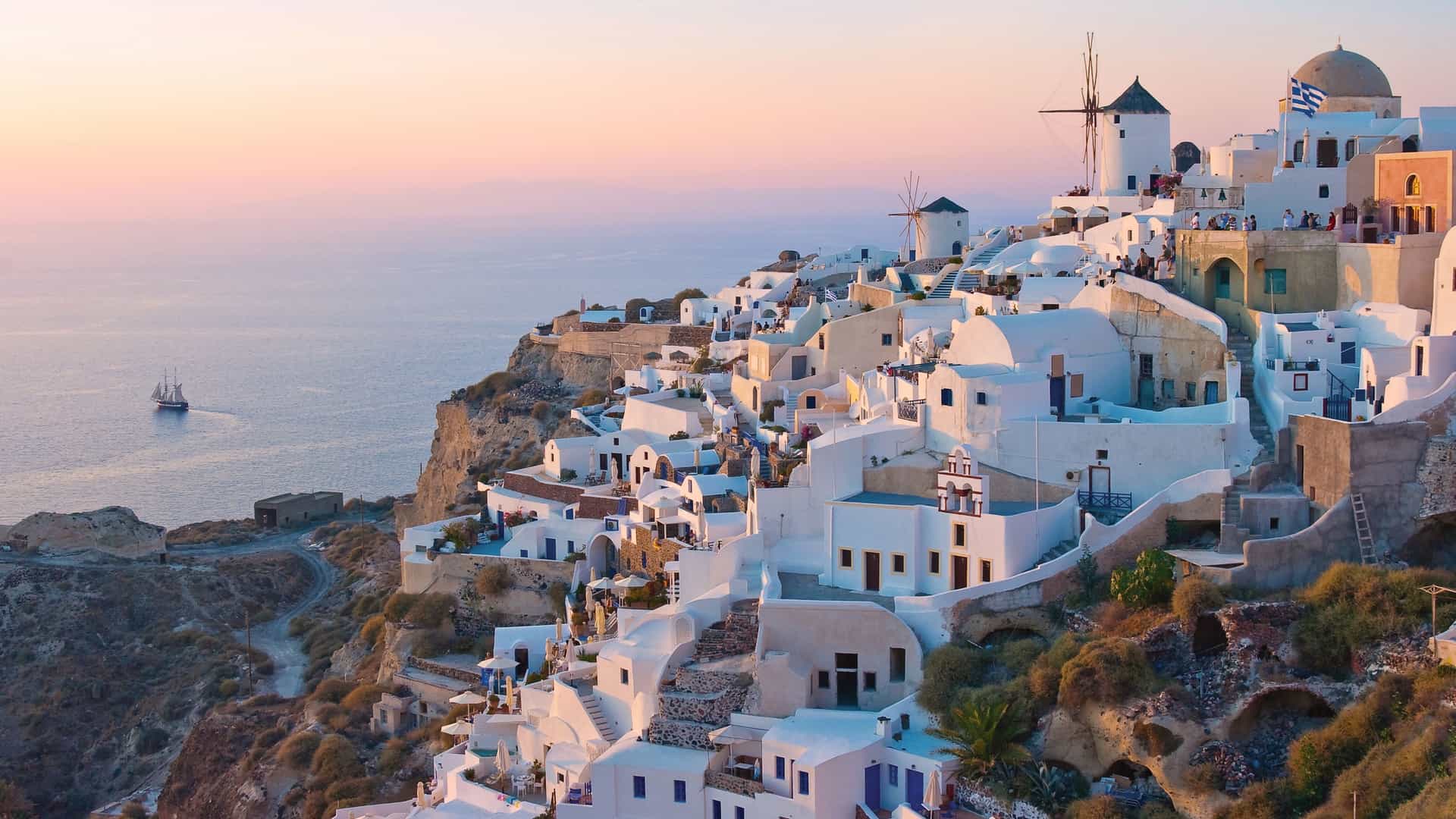 Norwegian Cruise Line guests marveling at the iconic white-washed villages and blue-domed churches of Santorini, Greece, a breathtaking European port of call.