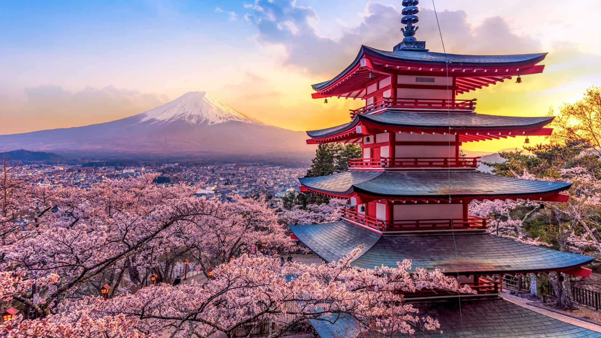 A scenic view in Asia, featuring the Chureito Pagoda and snow-capped Mount Fuji surrounded by vibrant cherry blossoms in Japan, a popular destination on Oceania Cruises.