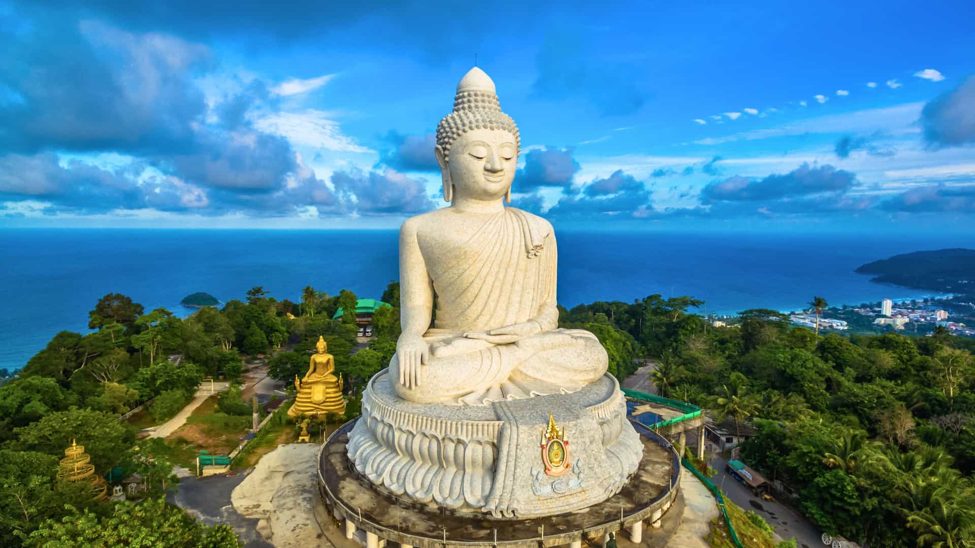 An Oceania Cruises view of the majestic Big Buddha statue overlooking the lush hills and azure Andaman Sea in Phuket, Thailand, a serene stop on a Southeast Asia cruise.
