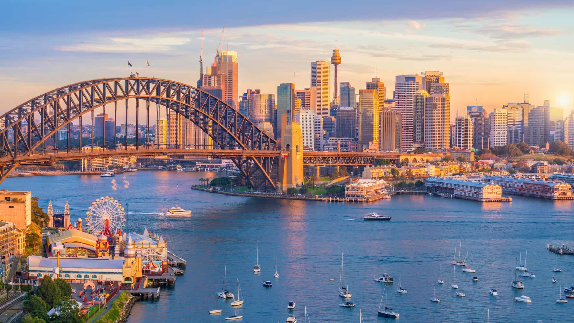 A beautiful view of the iconic Sydney Harbour Bridge and city skyline at sunset, as seen from a ship on an Oceania cruise in Australia.