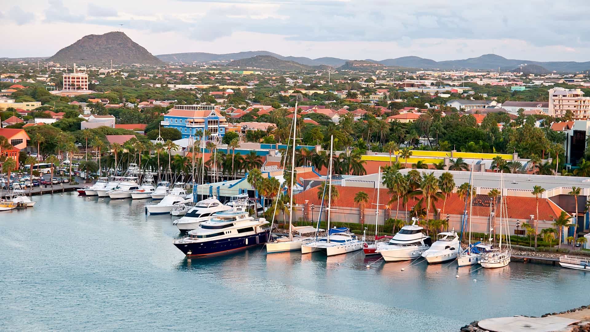 Oranjestad, Aruba harbor with boats and colorful Dutch architecture.