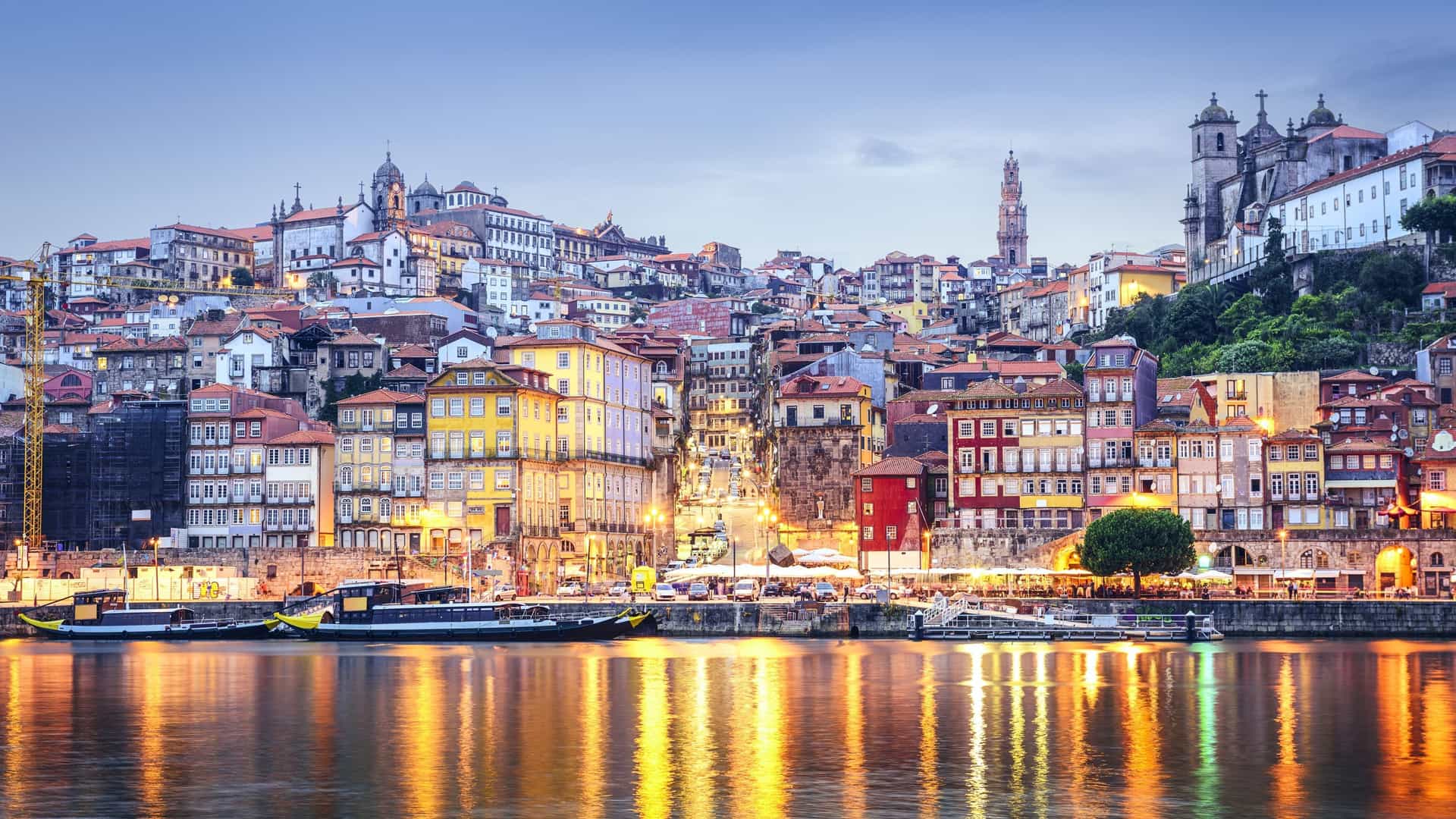 Historic cityscape of Porto, Portugal, along the Douro River at dusk.