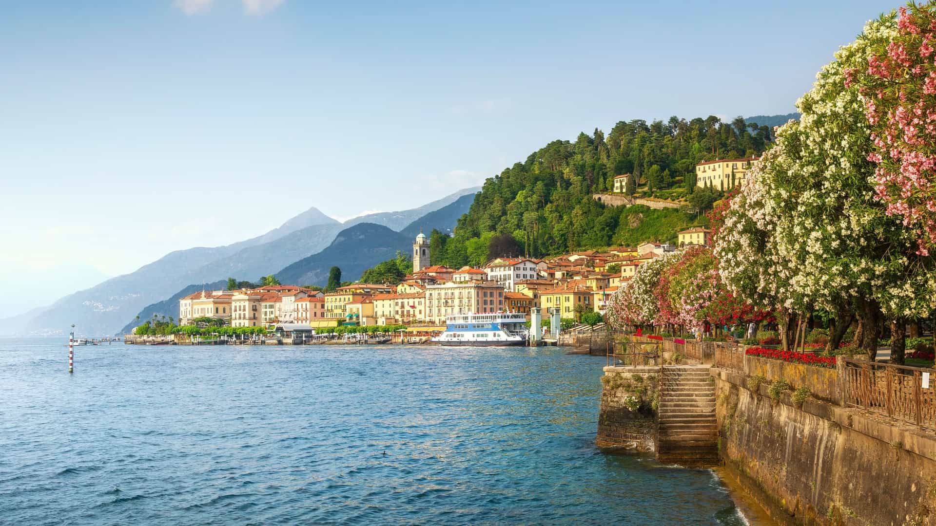 A panoramic view of Bellagio, Italy, showcasing the charming lakeside town with its elegant villas and buildings nestled on a hillside overlooking the tranquil waters of Lake Como.