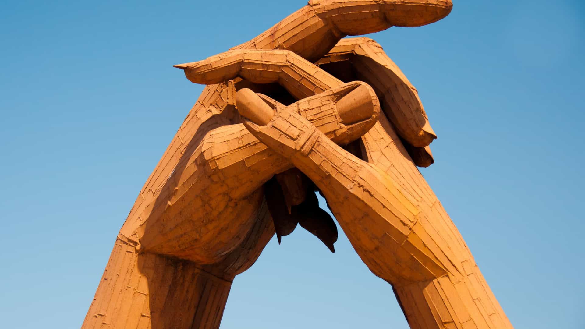 A close-up of the "Handfasting" sculpture, two massive hands clasped together, symbolizing love and marriage at the famous wedding destination of Gretna Green, Scotland.