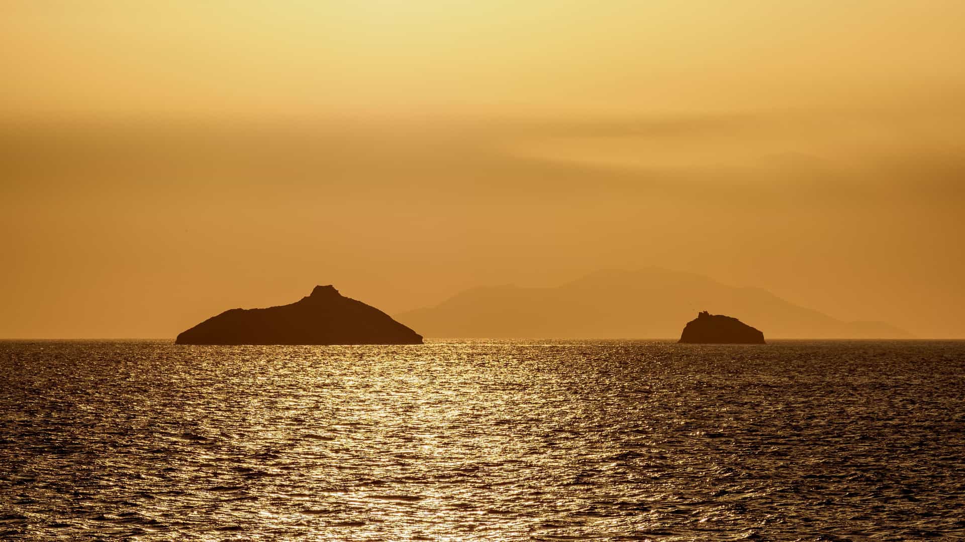 A beautiful sunset shot of the remote Isla Guy Fawkes islands, with the sun's golden light reflecting off the shimmering water.