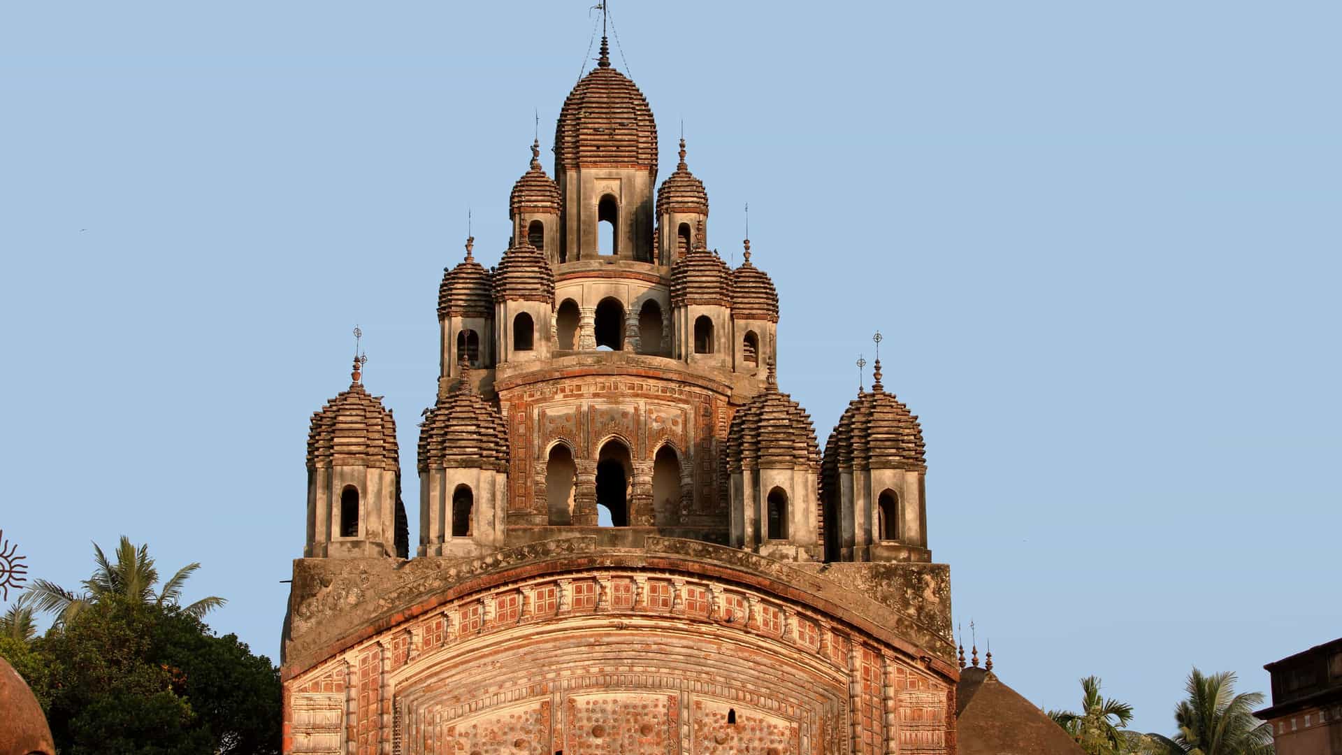 A stunning close-up of the architectural detail of the Nabakailash or 108 Shiva Temples complex in Kalna, India, showcasing the unique terracotta temple spires against a clear sky.