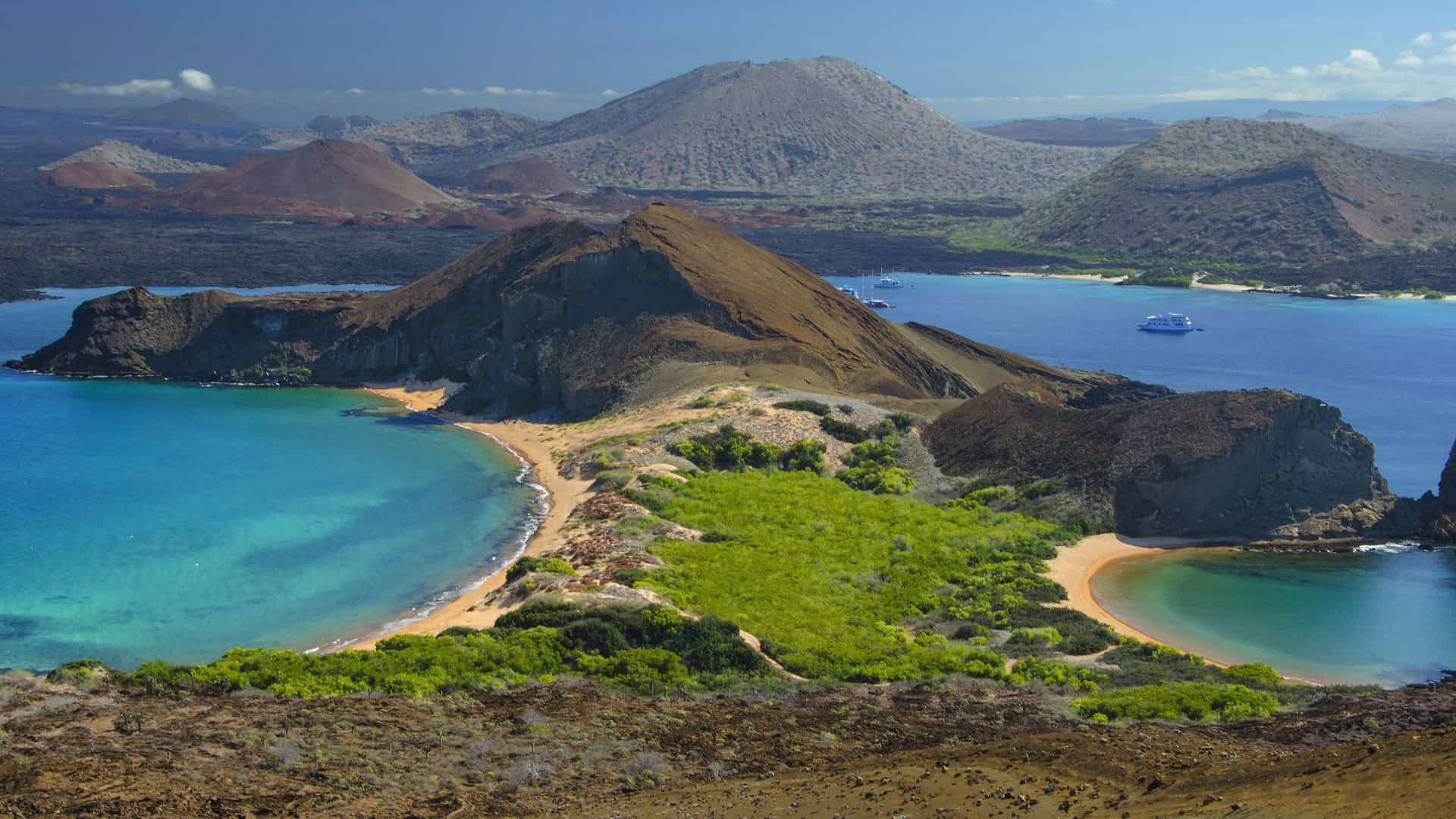 A scenic aerial shot of Las Bachas, a port of call on Santa Cruz Island in the Galapagos, showcasing a pristine beach with turquoise water.